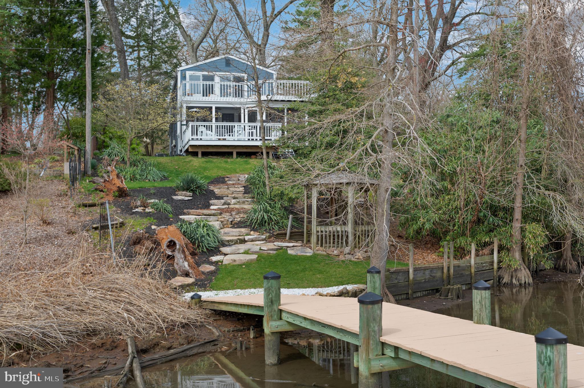 Imagine waking up, walking out onto your expansive deck from your primary bedroom to watch the sunrise over the water as you sip your morning coffee. This Severna Park waterfront home on a half acre offers unbeatable views from both an upper and lower deck, a true entertainers paradise. The lower deck has a screened in porch with overhead fans to keep cool on those hot summer days. The property itself is nestled at the very end of a dead end street, offering utmost privacy.
Inside, in the cozy living room, you will find custom stained, knotty pine walls and expansive windows to take in the views. Custom built-in book cases as well. In the kitchen, granite countertops and soft close maple cabinets along with a built in hot water feature for the tea lovers out there.
Upstairs you find all 3 bedrooms. The water- facing primary bedroom steals the show with glass sliders all across the water facing wall that open to a large wrap around deck. Truly breathtaking.
As you walk the half acre property, you will notice that instead of typical stairs, you have professionally hardscaped imported query stones combined with beautiful landscaping for an esthetic descent to your private pier. The pier has extra piles set for a future boat lift.
There is also an unfinished basement with 6ft 3 ceilings that is plumbed for a bathroom and kitchenette. It has its completely own side entrance, not accessible through the main home. Though the current owners use this space as generous storage, you can make it what you will- possibilities galore!
Many updates including a brand new roof! Pier painted and sealed, new carpet, all decks repainted, and boiler system updates all in 2022.