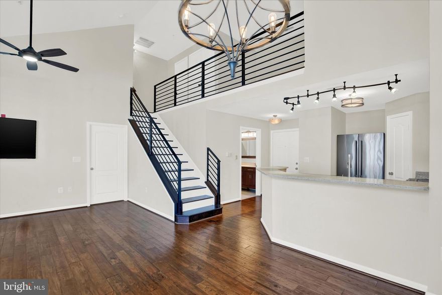 Rarely available top-floor, one-bedroom condo with loft in Hunt Valley's luxury High View community! This airy, light-filled unit offers an elevated feeling of space and scale with vaulted ceilings, an impeccable interior design aesthetic and upscale finishes throughout. It even comes with a deeded parking space conveniently located very close to the unit! The open concept floor plan connects the living room, dining room, and kitchen. This unit has a chic vibe with its neutral décor, beautiful hand-scraped engineered wood floors, high-end fixtures and industrial accents. The kitchen offers upgraded, custom 42-inch cabinetry and features all your foodie must-haves: quartz counters, stainless-steel appliances, a pantry and breakfast bar with seating. The dining room is perfect for intimate dinners and opens to the living room with cozy gas fireplace and adjoining covered balcony which overlooks the serene courtyard. The versatile loft space is accented with custom horizontal railings and provides an ideal office/flex space and additional storage. Retreat to the primary suite with spacious walk-in closet and spa-like primary bath with walk-in shower, removable rain showerhead and custom glass doors. Don't miss the laundry with shelving for even more storage! Enjoy the ultimate in resort lifestyle amenities with concierge service, outdoor pool, fitness center, tennis courts, movie theater, café, meeting room, library, card room, and office space. The entertainment options are endless! Elevator building with covered garage parking, conveniently located just minutes from Hunt Valley shopping, entertainment, and recreation with easy access to I-83 and I-695. This unit will not disappoint!