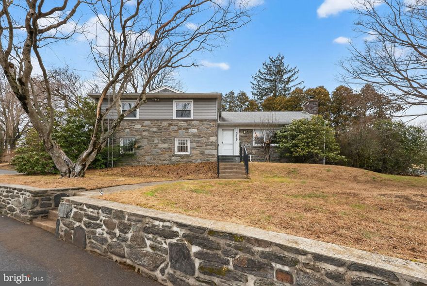 Welcome to 319 Crestview Circle, a well-built,  stone split-level home offering 3 bedrooms, 2.5 baths, and over 2,100 square feet of living space. Situated on more than half an acre, this home is tucked away on a private circle while remaining conveniently close to major highways, just 15 minutes from Philadelphia International Airport, and located within the award-winning Wallingford-Swarthmore School District. Homes in this highly sought-after neighborhood are rarely available, making this a unique opportunity.
Although the home is wonderfully retro and carpeted, beautiful hardwood floors run throughout the home, offering an excellent opportunity to restore and showcase their natural charm while adding immediate value. Enter the front door to find a spacious living room featuring a fireplace and a large picture window that fills the space with natural light. The living room flows seamlessly into the formal dining room and adjoining eat-in-kitchen, which offers abundant cabinet and storage space. Just off the kitchen is a generous sunroom with sliding doors that open to a beautiful, secluded patio, perfect for relaxing or entertaining. A short stair leads up to the bedroom level, where you’ll find a large primary suite with two closets, an ensuite bath, and custom built-ins for additional storage. Two additional well-sized bedrooms and a full hallway bath complete this level. This floor also features two separate access points to attic spaces, providing exceptional storage options. Back on the main level, another short set of stairs leads to a powder room and family room, an ideal space for a home office, playroom, or cozy retreat. This level also provides direct access to the attached two car garage. From here, continue down to the finished basement,  a wonderful bonus space for a work out or craft room.  Additional basement area includes the laundry, utilities and additional storage.
The expansive back and side yards of this half acre property features two storage sheds and offers plenty of room for gardening, outdoor activities, and entertaining. Residents of the neighborhood enjoy convenient access to the scenic Pendle Hill Trail, which connects to the Leiper Smedley Trail, perfect for walking, running, and enjoying the outdoors. While the home reflects its original vintage character, it offers excellent bones, location, layout, and timeless features, making it the perfect canvas for a buyer to add their own personal touches. Opportunities like this—in a neighborhood buyers covet —don’t come along often. Don’t miss your chance to make this home your own.