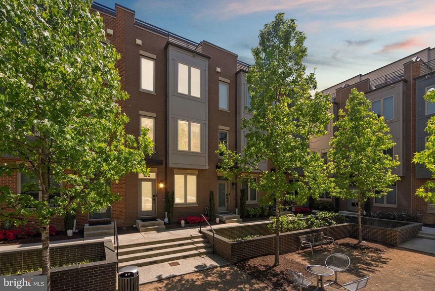 Nestled within a peaceful enclave in the City of Rockville, this stunning 3-bedroom, 3 full bath, 2 half bath townhome, built in 2019, offers four levels of beautifully designed living space, a private rooftop terrace, and secure garage parking.

Enter through the ground-level foyer, currently configured as a home office, complete with a convenient half bath. Upstairs, the sun-filled main level features an airy open-concept layout anchored by a sleek modern kitchen with white cabinetry, stainless steel appliances, and an oversized center island with bar seating. The adjoining dining area flows seamlessly into the inviting living room, where gleaming hardwood floors and abundant natural light create a warm yet sophisticated atmosphere. An additional half bath adds convenience to this level.

The next level offers two generously sized bedrooms, each with its own ensuite bath. On the top floor, you'll find an additional bedroom, full bath, and a versatile flex space ideal for a home gym, lounge, office, or guest retreat. Step outside to the private rooftop terrace — the perfect setting for morning coffee, sunset cocktails, or entertaining under the stars.

Complete with a one-car garage, additional driveway parking, and easy access to Pike & Rose, Rockville Pike, Twinbrook Metro, dining, shopping, and everyday conveniences, this thoughtfully designed residence offers the ideal blend of comfort, style, and convenience in one of Rockville’s most connected locations.