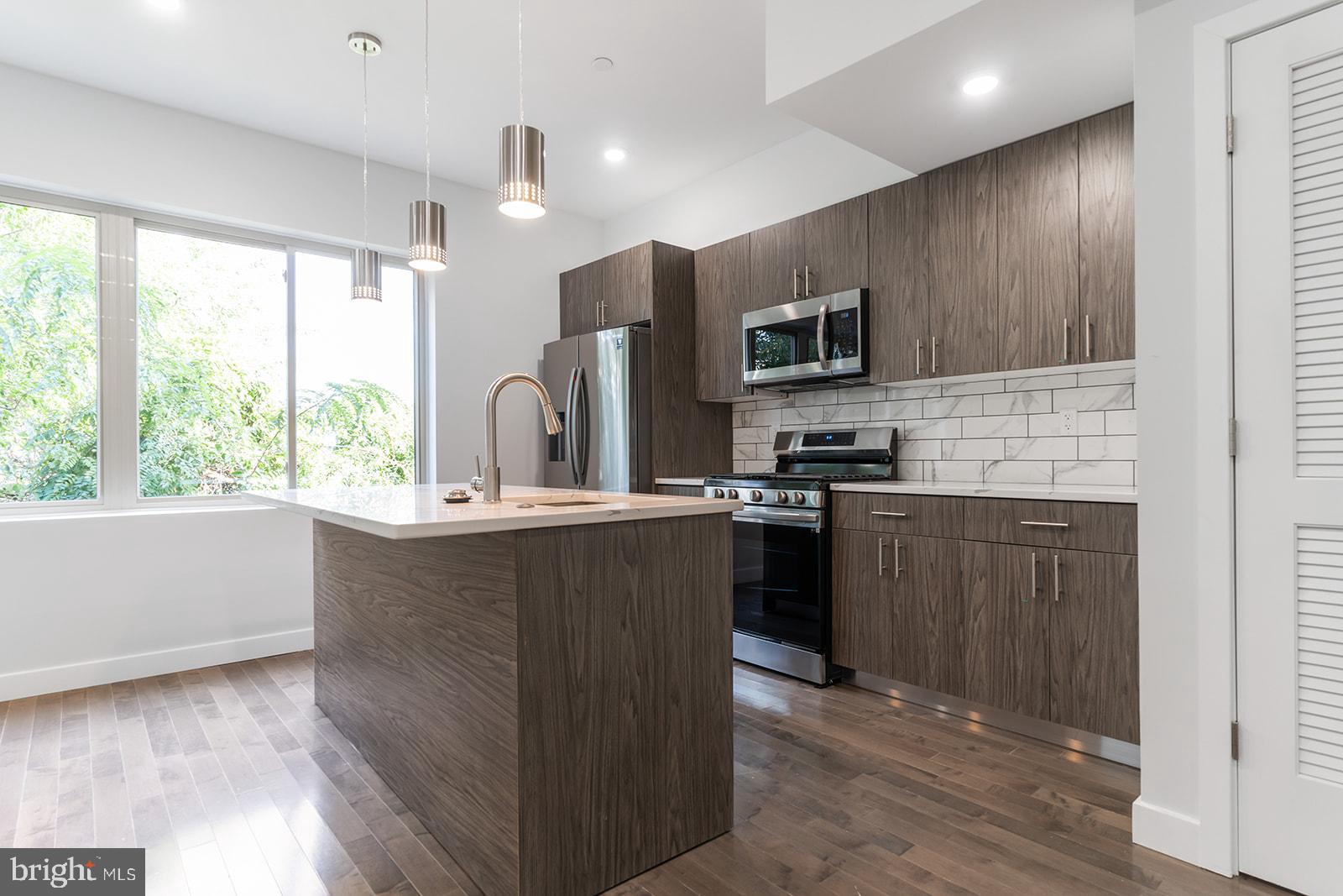 Boasting toasted oak hardwood flooring, fully-loaded kitchens, central air, and private outdoor spaces (hello, roof deck), 1945 N 7th St #4 comes equipped with everything you need to feel right at home. Upon entry, you are greeted by an open living and dining concept. The room is soaked with sunlight thanks to the oversized windows. Whether you're a Grub Hub gazelle or a meal prep maniac, the kitchen offers stainless steel appliances, driftwood cabinets with brushed nickel hardware, calcutta quartz counter tops, and contemporary pendant lighting to support any culinary lifestyle needs. A half bath completes the first floor. Head upstairs to have your pick of two oversized bedrooms, each with their own full tiled bathroom and dedicated closet spaces. Washer/dryer in-unit. Recessed lighting throughout. Private intercom system and smart thermostat! $40 application fee per applicant. Generally, first, last, and security are due upon signing. $35 flat water fee per month. Pet-friendly. Walking distance to Temple University, Cousin's Supermarket, Human Robot Beer, Luna Cafe, the Broad Street Line. Easy access to all the happenings in Fishtown, Broad St/611, and Girard Ave. Available now.