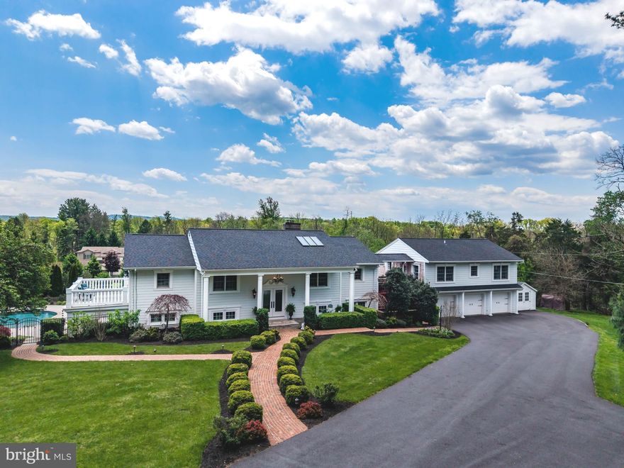 Through the gates, tucked away at the end of a long driveway on a picturesque and private 2.64-acre lot, this immaculate home has been thoughtfully updated and remodeled with premium finishes throughout and showcases exceptional attention to detail, including new Hardie Plank siding, grand entrance columns, new HVAC systems for both floors, new windows, and a new roof, gutters, and downspouts—delivering both beauty and peace of mind. Adjacent to a 26-acre park preserve with scenic walking trails, the setting offers a rare blend of privacy and natural beauty. From the moment you arrive, both the stunning interior and resort-style grounds deliver undeniable “wow” factor.
Inside, walls of windows and doors flood the home with natural light while capturing views from every angle. Both levels offer massive great rooms designed for comfortable everyday living and effortless entertaining. The main level offers two bedrooms, including a luxurious primary suite designed for comfort and privacy, featuring his and hers separate bathrooms, a cozy gas fireplace, a custom California Closet, and double French doors adorned with elegant plantation shutters that provide both privacy and light control while opening to a massive tiled balcony. The eat-in kitchen is equally impressive, showcasing Italian stone flooring, quartz countertops, new appliances, and a striking porcelain feature wall with a built-in fireplace and hand-crafted mahogany mantel.
The first floor is a full walkout and offers exceptional flexibility, featuring two additional bedrooms, a fully equipped bar with a second kitchen—perfect for guests, multigenerational living, or extended entertaining. A covered walkway also leads to a private guest quarters/in-law suite complete with two bedrooms, a full bathroom, a full kitchen, and a spacious family room.
Outdoors, the property transforms into a personal resort with a lighted multi-use sports court for pickleball, tennis, and basketball, a saltwater heated gunite swimming pool, a serene 15-foot koi pond with dual waterfalls, multi-level hardscape patios, and a wood-burning fire pit—perfect for entertaining or relaxing under the stars. Thoughtfully designed low-voltage lighting enhances the grounds. A three-car garage is complemented by a brand-new shed located directly adjacent to it, providing additional convenient storage.
This is a one-of-a-kind property offering luxury, privacy, and lifestyle all in one extraordinary package, conveniently located near Liberty Forge Golf Course, Lower Allen Community Park, and Yellow Breeches Creek.