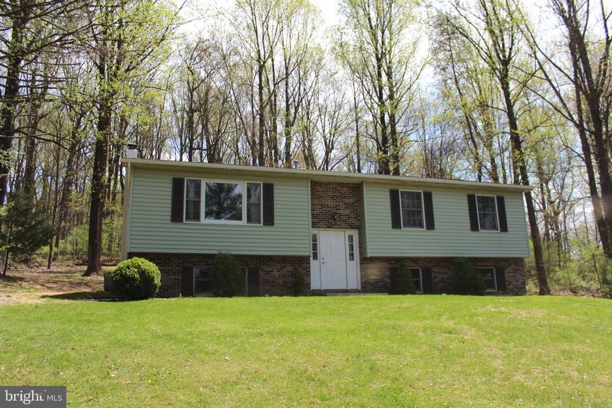 Welcome home to 306 Westley Rd! Located in the Twin Valley School District this home features 3 bedrooms, 2 full bathrooms, and 1 half bathroom! Main floor includes a spacious living room with large picture window, coat closet, kitchen, and dining room with sliding glass door to access the deck and backyard. The main floor also consists of the primary bedroom that has a private attached full bathroom, 2 additional bedrooms each with ample closet space, and a second full bathroom.  Heating system is located in attic space accessible by ceiling panel located in the closet of primary bedroom. The lower level basement area includes a large finished family room area with daylight windows and woodstove. This lower level also has a convenient half bathroom, 2 storage closet areas, and a laundry room. Water heater is located in laundry room area. Additionally a two car garage provides more storage and parking area. The home sits on a 1.58 acre lot that provides a balanced blend of open grass yard, shaded treed yard, and woods. A few established trails lead through the woods from driveway to yard areas. Outside you will also find a 16' x 12' deck, driveway with multiple parking spots, a chicken-coop, firepit, woodshed, and shed. Convenient location, this property is close to I-176 Morgantown Expressway, Route 422, and the Pennsylvania Turnpike.