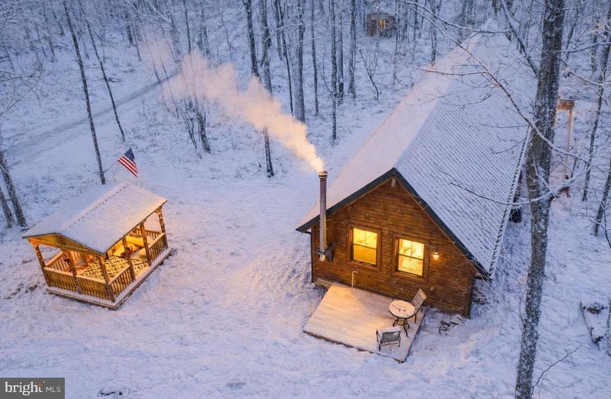 New Price! 
Experience the beauty of West Virginia living — a peaceful getaway where relaxation meets adventure.  Private River Retreat Cabin — Cozy Getaway with Loft & River Access!

Escape to your own woodland sanctuary in this charming cabin tucked into the mountains with private river access to the beautiful Cacapon River. Surrounded by peaceful hardwood forest and incredible wildlife scenery, this getaway offers unmatched privacy while still providing the perfect blend of rustic charm and modern comfort.

Step inside to a warm and inviting great room with soaring vaulted ceilings, natural wood finishes, and a wood-burning stove that sets the mood for cozy nights by the fire. The open layout features a spacious living area, a dining nook with large picture windows, and a fully equipped kitchen ideal for vacation living.

The main level bedroom and bath provide convenience, while the loft area adds extra sleeping space, office potential, or a fun bunk room escape—making this cabin perfect for full-time living, weekend retreats, or a short-term rental investment.

Enjoy the outdoors with cabin-style porches, hardwood shade trees, and easy access to the river for swimming, kayaking, fishing, and tubing. Whether you’re roasting marshmallows, watching the stars, or relaxing with a book by the wood stove, this serene property is built for slowing down and enjoying nature.