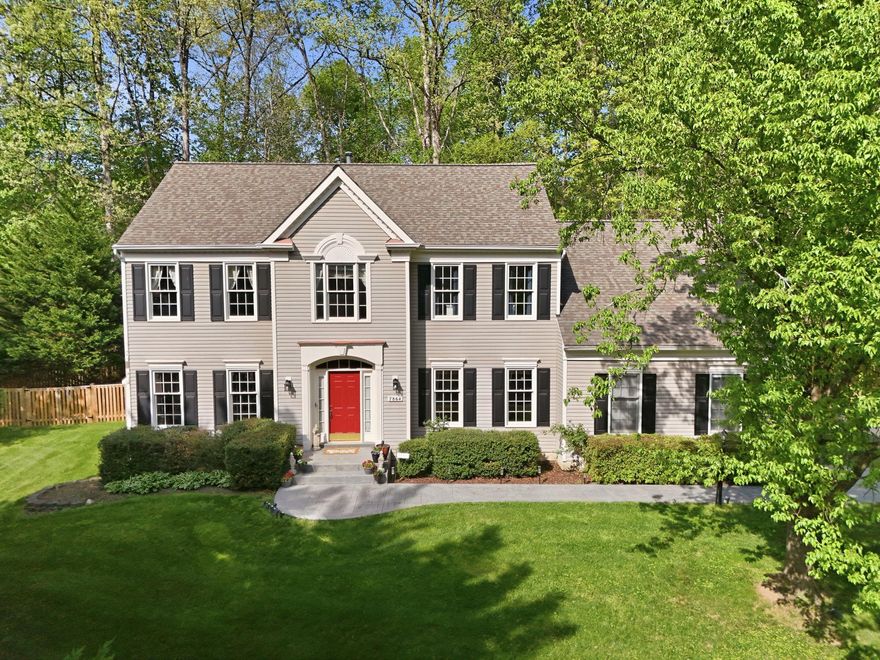 Welcome to the highly sought-after Meadowbrook Woods community!  Situated on just over a half-acre, this beautifully maintained home features a fully fenced rear yard, spacious deck, and a 2-car, side-load garage. The main level showcases stunning site-finished hardwood flooring, an upgraded kitchen with stainless steel appliances, granite countertops, and a bright, open layout.  Enjoy a dramatic family room with a cathedral ceiling, along with a formal dining room, a dedicated office, and a formal living room with a cozy gas fireplace.    Upstairs you will find four generously sized bedrooms and two full bathrooms, including a luxurious primary suite with a spa-like bathroom you truly must see to appreciate!  The finished basement offers incredible versatility, complete with a full bathroom, a large recreation area, and an impressive bar space featuring granite countertops, sink, wine cooler, extra refrigerator, and seating area—perfect for entertaining.  Plus, the convenience of a storage room, a workshop/mudroom that exits to the backyard and an additional office/open area. This home combines space, style, and functionality in an unbeatable location—don’t miss it!