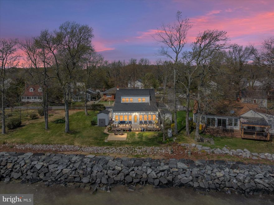 Truly special and exceptionally improved bayfront offering in the gated Columbia Beach community of Shady Side. This Classic Cape Cod is all about the experience and attention to detail—breathtaking Chesapeake Bay vistas, unforgettable sunrises and sunsets, and the kind of big-sky waterfront setting that makes this home feel like a retreat every single day. Seller has maintained detailed improvement and maintenance records, with $400,000 in documented improvements from 2022–2024. Highlights include replacement windows, plantation shutters, an owned security system that enhances the lock-it-and-leave-it lifestyle and allows you to keep an eye on the property from anywhere, whole-house Generac generator, extensive multi-zone mini-split installation for efficient heating and cooling, crawlspace encapsulation, water softener and reverse osmosis system, renovated primary suite and bath with walk-in closet, heated upper-level bath floors, Swedish-style hardwood flooring on the main level, recessed lighting, updated doors, kitchen renovation with upgraded appliances and fixtures, exterior improvements, and two workshop/storage sheds. Nearly 60 ft of rip-rapped non-riparian waterfront frontage, community access to the waterfront park, boat ramp, and pier, and seller states no flood insurance is currently required. This is a rare combination of scenic waterfront living, thoughtful upgrades, and strong utility and efficiency features. Near Franklin Point State Park, local marinas, and the outdoor lifestyle that defines Southern Anne Arundel County, the property’s setting delivers incredible light, dramatic skies, and extraordinary water views year-round. Ask your agent for the improvement ledger and maintenance documentation.