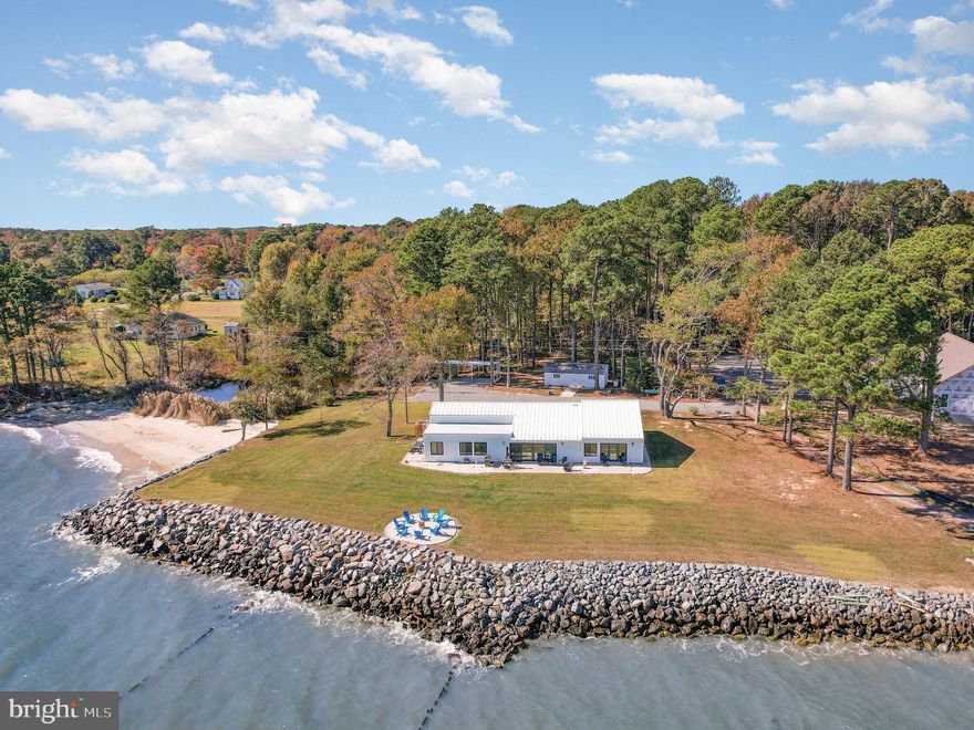 NEW PRICE!!! Experience Unmatched Premier Waterfront living with Sweeping Chesapeake Bay Views and Your very own Private Sandy Beach, this exceptional 4-bedroom, 3-bath coastal retreat offers a rare blend of serenity, natural beauty, and adventure. From the moment you arrive, endless water views and the soothing rhythm of gentle waves create an atmosphere of complete peace. Bald eagles soar overhead, dolphins playing, otters, turtles, herons and a plethora of wildlife to watch as nature truly surrounds you here.  Step through the front entry where natural light fills the space and take in the panoramic water views that define nearly every room. The open-concept main living area features luxury vinyl wide plank flooring, skylights, recessed lighting, and an airy layout perfect for both relaxing and entertaining. The spacious family room flows seamlessly to the large waterside patio, where you can enjoy unobstructed views of the Chesapeake Bay and watch as the Smith Point Lighthouse begins to send beacons of light at dusk. End your evenings by the firepit under a canopy of stars, listening to the gentle waves lapping on the rocks.  The kitchen & dining area is tastefully designed with simplicity & functionality in mind, boasting quartz countertops, a large island for all your hosting needs and meal prep, stainless steel appliances, recessed lighting & modern fixtures amplify the space, white shaker wood cabinetry with soft close doors & dovetail drawers. Ample storage in the built in pantries & a large walk in pantry and/or storage room just around the corner.  Just off the kitchen, two inviting bedrooms feature luxury vinyl wide plank flooring, ceiling fans, and windows framing views of the private beach & Bay. A full bath with custom tile flooring and a shower/tub combo completes this wing.  As you leave the dining area you are greeted once again with stunning Bay views from the flex room that can be a reading/sitting area, game room, study or whatever you want the space to be. The flex space connects to another flex room which leads you out to a second patio, perfect for outdoor dining. Back inside off the family room, conveniently located is a large full bath boasting custom tiled floors and shower, spacious laundry area and stylish finishes. A third bedroom, filled with natural light from a skylight, continues the home’s thoughtful design with recessed lighting and luxury vinyl wide plank flooring. Next up, the luxurious primary suite which is a true retreat. Wake each morning to the sun rising from the east illuminating the Chesapeake Bay right outside the wall of windows. The ensuite boasts a large walk-in tiled shower, double bowl vanity outlined by board and batten trim, a private linen closet, and a spacious walk-in closet with custom shelving. Step out onto your private patio to enjoy morning coffee, fresh air and unwind at night as ships pass by illuminating their path. Beyond the driveway lies the property’s tidal pond, a peaceful haven for herons, otters, and a beloved family of alligator snapping turtles who make a seasonal visit to enjoy the ripened persimmons. Just past the pond, your private beach awaits—ideal for kayaking, paddle boarding, fishing, sailing, or simply soaking in the sun and vitamin sea!!! This is your opportunity to own one of the most amazing properties on the Northern Neck. And just think, this could be your new home!!!