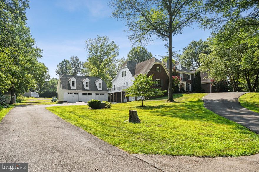 Welcome to this stunning residence where elegance meets functionality. The home features a main residence and attached carriage house, both with impressive 9' ceilings on the first floor and classic crown molding throughout. The floors boast rich hardwood and neutral tile, including tumbled marble in the main house foyer and porcelain tile in both kitchens, laundry rooms and most of the bathrooms. Stylish casement windows and pocket or glass-paneled doors enhance the open feel of the living spaces. The property includes unique vintage chandeliers that add charm to the interiors.
The main house kitchen is a culinary delight, equipped with a 48” Dacor dual-fuel range with six burners, a 48” Sub Zero built-in refrigerator/freezer, and a GE Cafe Advantium microwave oven (installed in 2023). The recently updated Bosch stainless steel dishwasher complements the custom ivory-painted cabinets and elegant granite countertops. The backsplash features hand-painted tiles, and the large center island includes an extra sink and bar-height peninsula. Herbeau faucets and Bouvet pewter hardware complete the upscale look. A whole house reverse osmosis system with a new holding tank (installed in 2023) ensures pure drinking water and ice throughout.
The family room of the main house boasts a wood-burning fireplace with a limestone front and hand-painted mantle. It opens to a covered porch and a large stone patio, enhanced with string lights and custom rods and cables installed in 2023. The main floor master suite offers a cathedral ceiling, large fan, and large windows with a transom. The master bath is a retreat with an air jet soaking tub, a separate shower, a water closet, and white Carrara marble with Herbeau fixtures and dual vanities. The suite also includes a spacious walk-in closet and a linen closet.
The large game room features a cathedral ceiling with a large fan and four chandeliers. It includes a wet bar with a reverse osmosis faucet, an ice maker, and a wine refrigerator. The walk-in pantry has a separate refrigerator, upper cabinets, shelves, and a dog shower. 
Upstairs, the master suite has hardwood floors, two large walk-in closets, new vanities, mirrors, and light fixtures, as well as porcelain tile, a water closet, and a linen closet. The dedicated laundry room is conveniently located on this floor. Additionally, there are three more bedrooms sharing a bathroom, with one bedroom featuring a walk-in closet.
The carriage house includes a spacious room with a cathedral ceiling, separate front entrance, and two rear entrances. Downstairs features a bedroom (currently used as an office), an open kitchen and family room, a bathroom with a slipper tub, hand shower and window seat, a pantry under the stairs, a dining area and a laundry room.  The kitchen is equipped with custom cabinets, a hand-painted tile backsplash, a gas cooktop, a microwave with an integrated vent, a wall oven and a recently updated Bosch stainless steel dishwasher.  The floors are a mix of wood and porcelain tile. Upstairs includes a loft with dormers, a full bathroom with a linen closet and shower, and an attic with a furnace. 
The property also includes a detached 3-car garage, built in 2022, which is extra deep with an unfinished upper level. Additionally, there is an attached 2-car garage. The property is equipped with a whole house surge protector and a diesel generator with a separate electrical panel for critical systems. There are four covered porches (two on each house) and two stone patios (one large patio off of the main house and one on the carriage house side yard). The fenced backyard has divided sections for the main and carriage houses.  The property is flanked by wooded conservation land - offering privacy and is zoned multi-use agricultural—providing versatility.  A truly unique and stunning home, offering endless possibilities!!