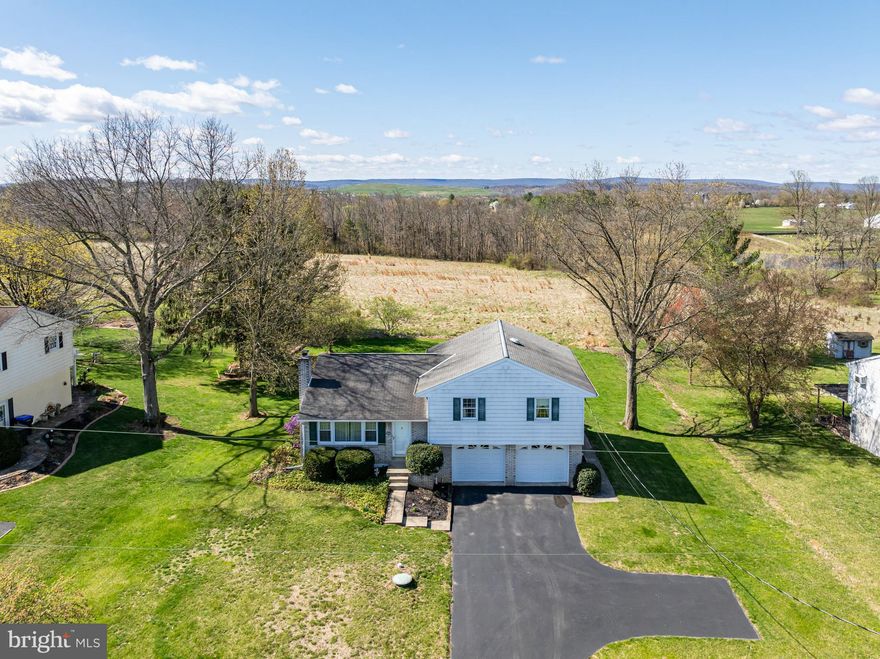This well-maintained split level located in a peaceful country setting.  The home has been lovingly cared for over the years and is ready for you to add your personal touches to truly make it your own!  Step inside to the living room with an expansive picture window that fills the space with lots of natural light.  The layout seamlessly connects the kitchen and dining room, perfect for everyday living and entertaining.  The kitchen features plenty of cabinets and stainless-steel range and refrigerator.  There are three generously sized bedrooms, including the primary bedroom with powder room.  The hall bath is spacious and has a built-in vanity and laundry area with a washer and dryer included.  The lower level has a large family room with a charming beamed ceiling and a wood-burning brick fireplace, an ideal space to relax or gather with family.  An Additional room in the lower level offers great potential as a workshop, craft room, or gym.  The home has a water treatment system and central air.  The oversized two car attached oversized garage offers plenty of space for your vehicles and your tools.  Outback, enjoy the large, flat backyard for gardening or play.  This great home is located in a quiet neighborhood!  Don’t miss out!!