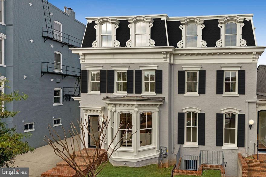 Created by Brush Arbor Home Construction's masterful collaboration of architects, interior designers, and landscape architects, this total renovation of one of Frederick Douglass' former residences is a four-level Second Empire-style elevator townhouse of impeccable elegance and exceptional scale. Providing bespoke tranquility in a coveted location just a couple blocks from the Supreme Court, Capitol and Senate Buildings, no detail has been overlooked in the custom renovation of this architectural gem.  Here, luxury and sophistication clearly meet modern day amenities and lifestyle needs.    A spectacular open floor plan integrates 10' ceilings, custom interior and exterior millwork, hand-milled white oak floors, Jeld Wen windows and doors, designer bespoke finishes such as lighting by Visual Comfort and fixtures by Kallista and Waterworks; all provide breadth and airiness on the main level. The front foyer's brick accent wall offsets the generous living room with fireplace and classic bay window, both complemented by the highest quality fixtures and finishes. There is a seamless flow from indoors to outdoors from a custom 15' wall of glass windows and doors to the private terrace, capturing an abundance of natural light adjacent to the chef's kitchen with its rigorously curated appliance package and breakfast room. The second level features a large landing and includes a well-appointed primary suite with two walk-in-closets, and spa-inspired bathroom. All five secondary bedrooms, spread across three levels with elevator access echo the primary's luxury finishes and closet or dressing room space.   The penthouse level offers a sublime north-facing city view from the relaxing vantage point of a family room with wet bar. The exceptionally crafted lower level includes an exercise room, second laundry room, as well as a secondary bedroom on this level. Access to the garden from the lower level thereby provides excellent flexibility for au-pair or in-law living configurations. The exterior has been planned with the utmost discernment, executed to provide a private backyard retreat which features a stone patio, shaded by strategically chosen, well-placed greenery, and a 2-car garage. The residence also conveys with two additional one-car garages across from the alley, just kitty-corner to the NW rear corner of the property.