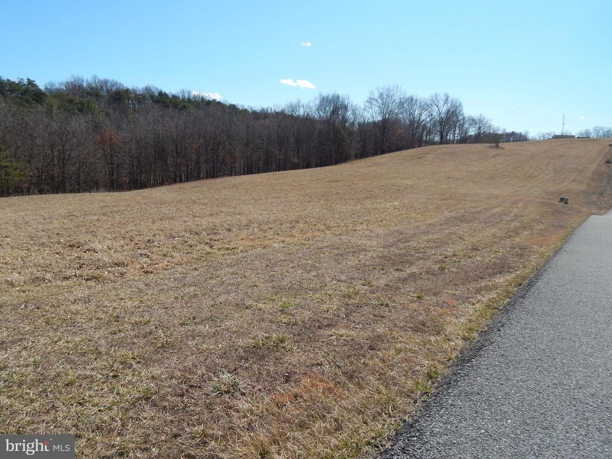 Located just 2 miles from Berkeley Springs in a pristine community with paved roads and underground utilities, this 6.703 acres is the perfect for your dream home with easy access to county road   Originally 2 adjoining lots that are taxed as one parcel.   Land  is level to sloping with paved road, with light restrictions.