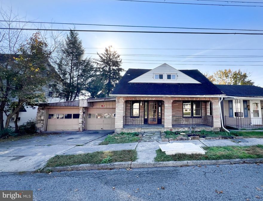 Don't miss this investment opportunity. Main house has warm wood feel, fireplace and large living room. Upstairs are 3 bedrooms and refinished bathroom. Attached is 2 car garage with fireplace. Just past the garden in rear of house is a further 3 car garage; access from alley. Above is a partially remodeled 2 bedroom apartment with fireplace. Brand new metal roof . Apartment in rear is over 1200 sq ft. Garage 848