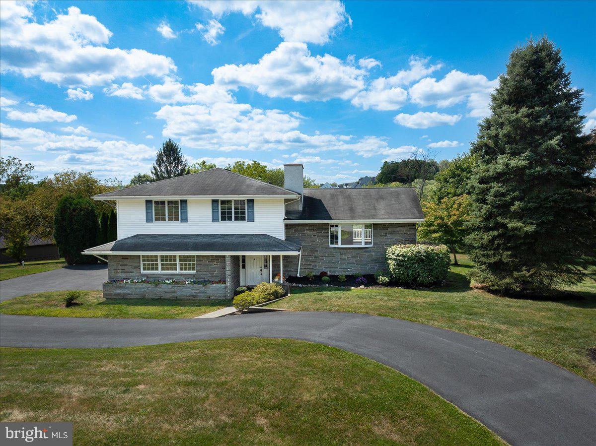 Set on the edge of Marsh Creek Lake in a quiet cul-de-sac on a private 1-acre lot, this extremely well-maintained home offers flexible, multi-generational options! Featuring 4 spacious bedrooms and 3 full baths, in over 2,400 SF of living space, this lovely multi-level home has everything you need in a beautiful and peaceful setting. The welcoming front porch and entry feature gorgeous stone accents and lead to the curved stairs which suggest a contemporary vibe. The huge living room is bright and open with a large bay window and anchored by a stone fireplace. It flows into a spacious formal dining room with custom molding and direct access to the recent composite deck. The kitchen is a great spot to pursue your culinary delights and features a deep farm sink, new flooring, and access to the Florida Room. This 3-season room is flooded with natural light and overlooks the big open yard with view of the lake beyond. Heading up the curved stairs, the primary suite features large closets and a walk-in shower with grab bars. Two additional spacious bedrooms, serviced by an updated full bath complete this level. Back downstairs to the ground level, you will discover a 4th bedroom with its own private entrance and full bath with grab bars. This is a great space for anyone with mobility issues as there are no steps, and a private entrance from the sunny patio! The laundry and access to the 2-car garage are also on this level. On the lower level you will find another great space for a home office, gym, or playroom for the kids. There are also two large utility rooms for storage. Outside, this home has tons of parking thanks to the recently resurfaced circular drive, parking area, and garage. The big backyard is ideal for family football games or barbecues and thanks to the patio, deck, and sunroom there is no shortage of outdoor entertaining spaces. Just a few cosmetic updates after moving in and this Downingtown charmer will sparkle! Recent updates include remodeled bath, deck, driveway, water heater, and carpeting. They say location is everything in real estate and this home has it! Set on a cul-de-sac in a quiet neighborhood, it is on the edge of Marsh Creek State Park, offering endless outdoor activities including boating and fishing on the 535-acre lake, as well as hiking, mountain bike riding, and horseback riding in the park. You are just minutes from the action in Downingtown’s downtown, and close to West Chester, Malvern, Phoenixville, and King of Prussia. With access to I-76 close by, getting around the region is a breeze. Check out this amazing home while it lasts!