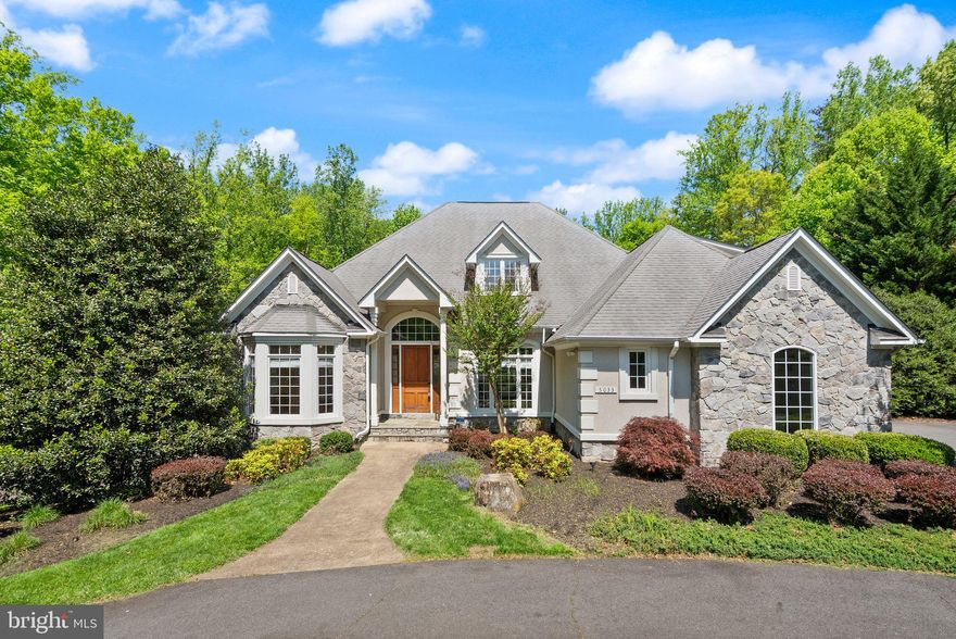 Set on 5 private wooded acres in a prime Fairfax location, this custom-built 5-bedroom, 5.5-bath French Country estate delivers the space, privacy, and resort-style living that rarely come to market, all just minutes from major commuter routes and everyday conveniences. From the moment you arrive, the circular driveway, stately stone and stucco exterior (DryVit system), and 3-car side-loading garage create a strong sense of arrival and set the tone for what’s inside.

Step through a custom 9-foot wood entry door into a dramatic two-story foyer, where hardwood floors, a sweeping staircase, and natural light immediately highlight the home’s scale and craftsmanship. Designed with both everyday living and entertaining in mind, the main level offers a seamless flow between formal and casual spaces, including a sun-filled living room, a private library with bay window, and a spacious family room anchored by a stone fireplace and a wall of windows overlooking the property.

The gourmet kitchen is built to perform and impress, featuring granite countertops, a tumbled marble backsplash, 42-inch cherry cabinetry, high-end stainless steel appliances, a gas cooktop with vented hood, wine chiller, and a large walk-in pantry. It opens directly to the dining area and outdoor living spaces, making it ideal for hosting at any scale.

A true highlight for today’s buyers, the main-level owner’s suite offers both convenience and privacy, complete with a sitting area, private balcony, custom walk-in closet with washer/dryer hookup, and a fully renovated spa-style bath with dual vanities, jetted tub, and an oversized walk-in shower.

Upstairs, four generously sized bedrooms provide flexibility for family, guests, or work-from-home needs, each with access to private or dual-entry baths, along with a bright upper-level laundry room.

The fully finished walkout lower level expands the home’s versatility with 9-foot ceilings, bamboo hardwood flooring, multiple recreation spaces, a game room, kitchenette, full bath, and a dedicated bonus/hobby room, making it ideal for entertaining or multigenerational living.

Outside is where this property truly separates itself. A custom natural stone patio surrounds a 50-foot Gunite pool featuring a diving board, slide, waterfall, and brand-new heater, all set against a backdrop of mature trees and open lawn, creating a private, resort-style setting that’s difficult to replicate in Northern Virginia.

Additional upgrades include fresh paint, refinished hardwood floors, new carpet, updated fixtures, a 3-zone HVAC system, two gas hot water heaters, backup generator, and extensive hardscaping, offering true move-in readiness.

While the setting feels completely private, the location keeps you connected, with quick access to Braddock Road, Fairfax County Parkway, Routes 29 and 50, and I-66. Fairfax Corner, Fair Oaks Mall, and the Mosaic District are all within easy reach, along with George Mason University and a wide range of dining, shopping, and entertainment options.

A rare opportunity to own acreage, a custom build, and a resort-style outdoor experience in one of Fairfax County’s most convenient locations. Schedule your showing today!