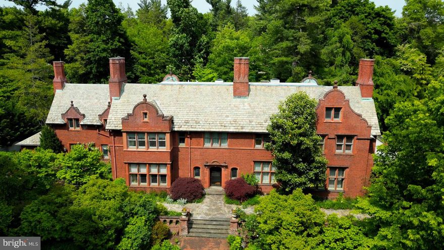 Philadelphia at its best.  Once in a generation opportunity to own one of the most significant properties in the City, "Binderton" was  designed by Cope & Stewardson Architects (also designed for University of Pennsylvania and Princeton).   The house was started in 1903 and finished in 1906.   The renowned landscape architecture  firm of the Olmsted Brothers was engaged to handle landscape, hardscape, and garden design.  During their ownership, the present owners purchased 461 W Chestnut Hill Ave. (which had been subdivided from the original plot many years earlier)  demolished the modest house that existed, and expanded the property and gardens, and  redesigned the driveway.  Situated on the quietest street in Chestnut Hill and surrounded by homes of equal caliber, Binderton stands out with its brilliant red brick construction and distinctive Jacobean Revival style , with shaped parapets, and intricately designed chimneys.   In most places, the house is designed only one room deep and was built linearly, near the property line at the high side.  The brilliance of the Olmsted Brothers work is apparent in the brick walkway  that rises gracefully from Towanda Street up a gradual hill with a low step every 10 feet or so.    From the stone patio, enter the front door  into the formal entry hall with main staircase at the back. The foyer is filled with natural light from two sides, a fireplace, a  powder room, and a large coat room with window.  Again from the  entry hall, walk into, what was  called in 1906,  the "Ladies' Parlor", a sunny, elegant sitting room with big windows and a fireplace.   The formal living room with two distinct seating areas, beamed ceiling , and wood burning fireplace can be accessed from the "ladies' parlor" or directly from a hallway.  The exterior door off the living room leads to an open air loggia with tiled floor and finished ceiling.  To the left of the front door, head to  the formal dining room with fireplace, elegant crystal chandelier and room for  a second dining table!  The kitchen has everything you want.  From the front hall,  head through the butler's pantry with lighted cabinetry,  porcelain sink , and dishwasher: a  great spot to set up the bar on party nights.  Further on you reach the supersized chef's kitchen with two sinks, three ovens, a gas range, banquette seating for conversation while prepping dinner,  stools at the counter for breakfasts on a busy day, and a big table at the end of the house  for casual dinners. Off the kitchen is a huge pantry area and laundry room.  Beyond the kitchen end is a glassed in garden porch that will serve myriad functions that make daily living more convenient.  Head up the carved and turned staircase and turn left at the top to reach the primary suite, that includes the bedroom with fireplace and door to second floor balcony, a cozy sitting room, great for reading or streaming late into the night, a beautiful, bright corner office/den, and a spacious bathroom with two sinks and walk-in shower.  On the second floor to the right of the main stair are four additional bedrooms, two of which share a Jack-and-Jill bath ; and two others that share an additional hall bath.   The third floor has three  bedrooms, a full bath, and a large central room, perfect for play or privacy.   The 1.6 acres that surround the house defy description.  Mature trees, abundant perennial beds, lush lawns, and garden rooms; one prettier than the next.  The main focus in the summer is the pool area. Exquisitely private with its walled garden, and elegant brick veranda, it is here where you can escape from the sun and the world.    Built to span the ages,  "Binderton" will pass to someone who loves grand old  houses and understands stewardship.