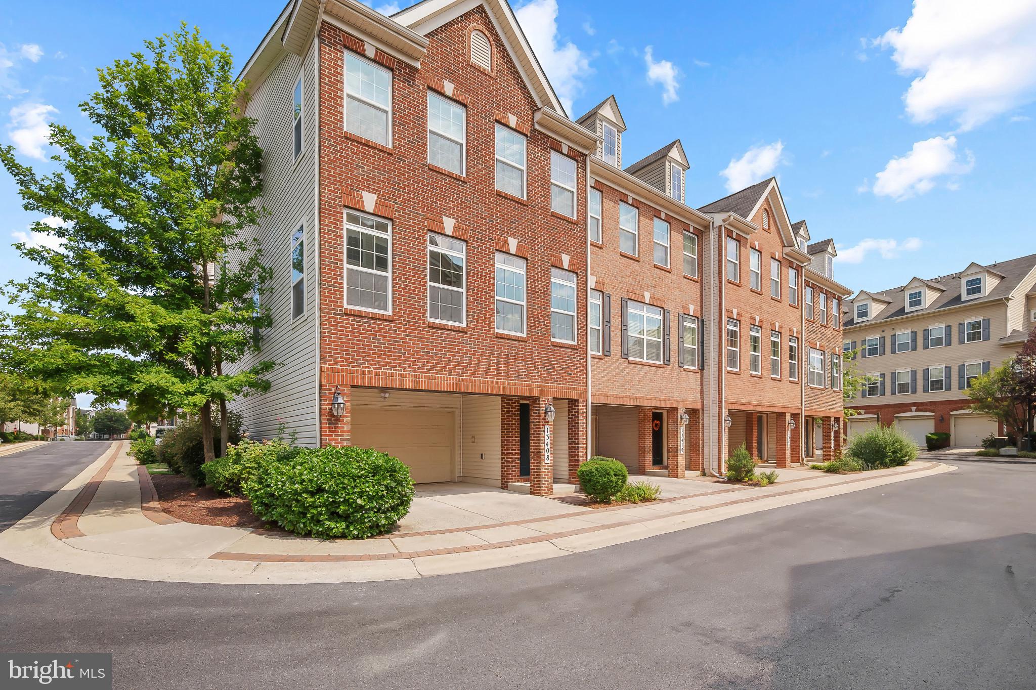 Spacious and light-filled, this end-of-row townhouse in desirable Gateway Commons offers 2,686 square feet of living space, 3 bedrooms, 2 full baths, 1 half bath, and a 2-car garage. The entry-level foyer features hardwood floors and leads to a versatile recreation room with carpet, ideal as an additional living space or home office, with walkout access to the back patio. Upstairs, the combined living and dining area includes plush carpeting, abundant natural light, and a dining space defined by a classic chandelier and chair rail detail. The kitchen includes hardwood flooring, an island with breakfast bar seating, upgraded countertops, stainless steel appliances, a pantry, a warm-toned backsplash, and access to a balcony. Just off the kitchen, the family room centers around a cozy gas fireplace and features continued hardwood flooring. A convenient powder room completes the main level. The upper level hosts three generously sized bedrooms, including a spacious primary suite with a sitting nook, a walk-in closet, and an en suite bath featuring dual vanities, a large corner soaking tub, and a separate shower. A centrally located laundry room and a second full bath with double sinks in the hallway add convenience for all.