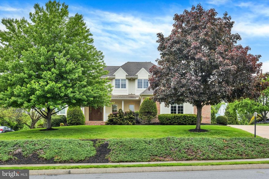 Welcome to this stunning home situated on a spacious cul-de-sac in the highly desirable Windmere community! Offering over 2,613 square feet of beautifully finished living space this home is filled with timeless character and exceptional craftsmanship throughout. The charming covered front porch creates the perfect space to enjoy peaceful mornings and evenings. Step inside to a grand two-story foyer featuring tile floors and cathedral vaulted ceilings. The formal dining room showcases hardwood floors, chair rail, tray ceiling, crown molding, and elegant window treatments. The impressive living room offers hardwood floors, soaring vaulted ceilings, arched architectural details, and a striking floor-to-ceiling stone wood-burning fireplace, a great space to host guests. The spacious kitchen is equipped with tile floors, ample cabinet space, recessed lighting, double ovens, pantry storage, and an eat-in breakfast area with a bay window and outdoor access. French doors lead to a cozy office complete with hardwood floors, chair rail, and window treatments. The main-level primary suite features plush carpeting, elegant crown molding, a bay window, and an attached bath with double sinks, soaking tub and a walk-in closet. Convenient main-level laundry room with tile floors, built-in cabinetry, sink, and counter space. Upstairs, you will find three additional bedrooms and a full bath with double sinks. Enjoy outdoor entertaining on the paver patio overlooking the cleared backyard. Additional highlights include an oversized three-car garage with high ceilings, unfinished basement offering ample shelving and a walk-up attic for conveient storage, newer hot water heater (2018), and newer gas furnace (2021). Conveniently located to shopping, dining and entertainment. A joy to own!