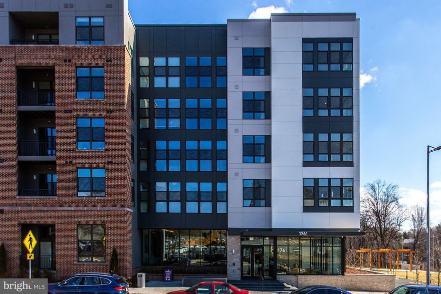 Elegance and convenience intersect at the Bexley, a new condominium completed in 2020, which brings luxury living to the McLean/Tysons corridor.  Unit 215 is a bright and spacious home with a warm and inviting gourmet kitchen with a large waterfall island and an open living room with plenty of space for a dining table. Upgraded LVP flooring flows throughout the home.  This unique floorplan allows for privacy with two  large bedrooms at either end of the home, both with upgraded en suite bathrooms and spacious walk through closets.   The primary bedroom has direct access to a private balcony, while the primary en suite bath features a frameless glass shower and dual vanity. A thoughtfully designed custom closet completes the primary suite. Down the hallway off the kitchen is the unit's half bath and a versatile third bedroom with spacious closet which could serve as home office or den.  Every window in the home is equipped with shades, with the addition of blackout shades in the primary bedroom.  There is a second balcony off the main living area as well as a separate laundry room with an in-unit washer/dryer and ample storage.  Ceiling fans were added in the primary bedroom, den and living room. Additionally, this unit conveys with two assigned garage parking spaces and a separate storage unit in the building.  Community amenities in this secured building include concierge, package acceptance service,  fitness center, elegant common/party room, elevated central courtyard with built in grills and a variety of dining and lounging options,  car charging stations, as well as a bike room. The Bexley is unbelievably convenient to Tysons,  McLean Metro, Wegmans, and Capital One complex, with extremely easy access to 66, 495, downtown McLean, and Tysons Corner Center.