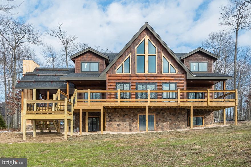 Stunning, almost new Mountaineer Log Home situated just steps from Lodestone Golf Course with filtered lake views! Recently painted throughout, this home has it all. Plenty of space, wonderful location and mountain views that go on forever. This home offers six en-suites, each boasting very nice private baths. Three levels of living space which includes a lower family room featuring a stone fireplace and wet bar.  The main level catches your eye from the moment you enter the door with plenty of large windows and doors allowing the beautiful outside in. The kitchen and dining area are well thought out for entertaining family and friends. The kitchen has been totally renovated to include all new cabinetry, high end appliances, wine cooler, built-in microwave, ice maker and 48" range w/double ovens. If the inside doesn't take your breath away, just step outside to the large deck and enjoy the views from all directions. The deck offers a covered space featuring an impressive stone fireplace. The home also includes beautiful French doors downstairs making it very easy to access the large hot tub, perfect to enjoy during any season. The location of this home is in the heart of Deep Creek Lake, just minutes to Wisp Ski Resort and Deep Creek Lake.