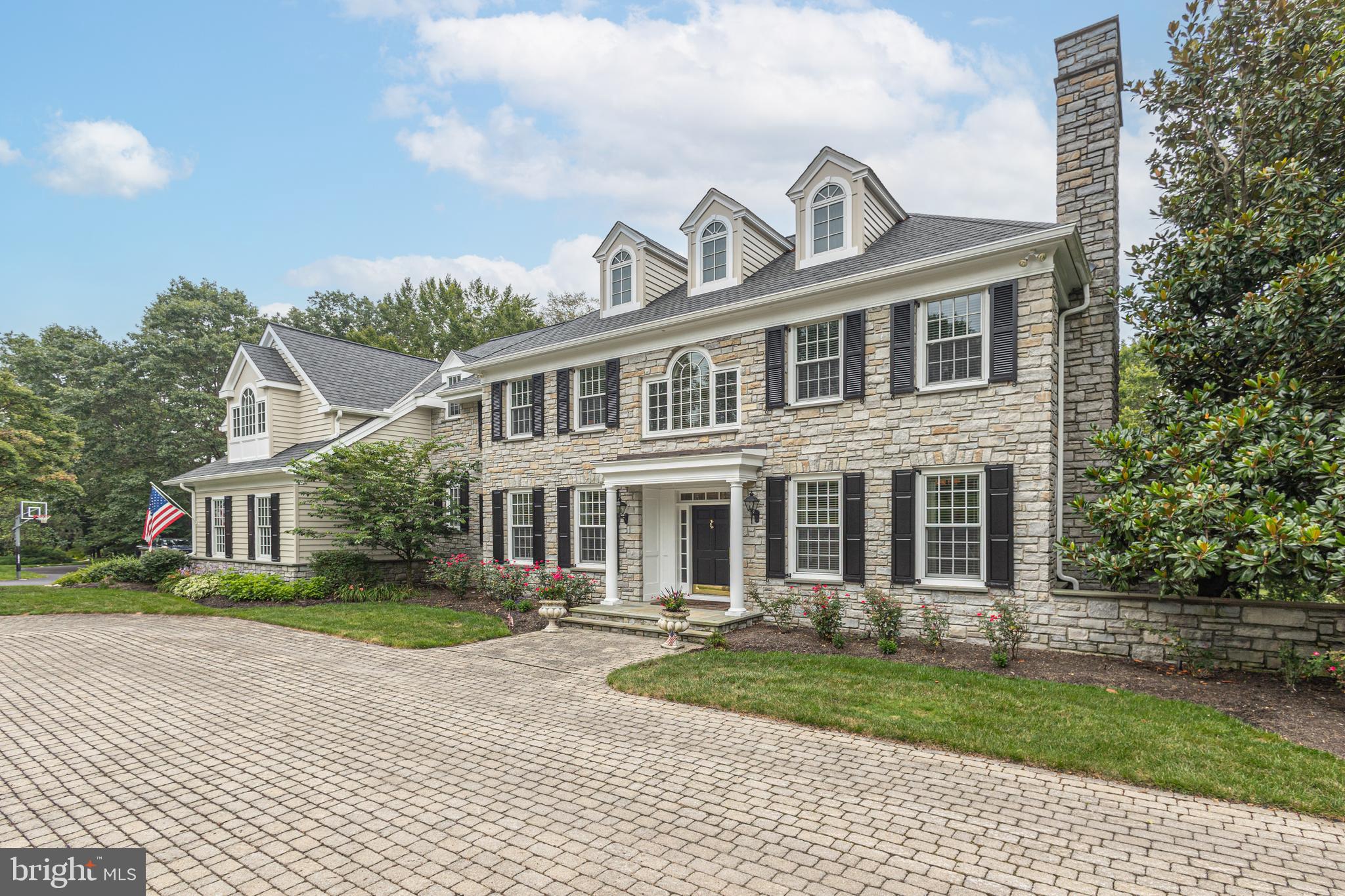 Discover the Classic Elegance in Exclusive Ely Farm! Just beyond the expansive paver courtyard in the prestigious Ely Farm enclave, this stunning center hall estate offers timeless architecture, luxurious finishes, and exceptional indoor/outdoor living. Set on a private, professionally landscaped lot surrounded by mature trees, this home features incredible outdoor spaces ideal for entertaining or relaxing in total privacy. Inside, you'll find elegant wood flooring, transom windows, an open staircase with a dramatic wall of windows, three fireplaces, and custom lighting throughout. The designer kitchen is a chef’s dream—featuring a large center island with seating, commercial-grade appliances, and expansive prep areas—opening to a bright Morning Room with tray ceiling. The spacious Family Room offers a coffered ceiling, built-in surround sound, and access to a private patio. A sun-drenched Study with custom built-ins and walls of windows provides the perfect home office. Upstairs, discover four generous en suite bedrooms and four-zone heating and cooling for ultimate comfort. The luxurious Primary Suite is a true retreat—complete with a Sitting Room, 3 Walk in closets, vaulted ceilings, and a wall of windows. The suite includes marble baths, an oversized shower with triple shower heads, and radiant heat flooring. The fully finished Lower Level is designed for entertaining, with a full catering kitchen (including dishwasher), Media Room with fireplace, guest bedroom, full bath, and a spectacular wine cellar—all with walk-out access to a second private patio. Recent updates, super convenience to Princeton & I 295, and award winning Council Rock Schools complete the offering. This exceptional home combines classic elegance with modern luxury—truly a rare find in Ely Farm.