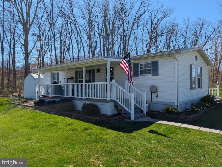 Community living and all of the amenities are here! Located amongst the Allegheny mountains in beautiful Friendship Village, this corner lot, 1990 doublewide has all you need in a 55+ community. Two bedrooms, two full baths, a living room, kitchen, dining room, and laundry area. This home also boasts a large covered front porch for all the summer swinging and porch sitting you desire, and a 3 season room with built-ins. This home has a front door padded lock system, NEW (2024) metal roof with warranty from Kauffman metals, new roof on shed, newer dryer (2023), water heater (2022), and carpet tiles (installed 2022) in bedroom. Home has oil forced air heat or use the newer mini split for heating and cooling. A paved driveway with parking for 4 and mature landscaping. Enjoy living in Friendship Village with all the amenities. $330 lot rent includes garbage. Swimming, miniature golf, convenience store and activities in the village galore will keep you entertained. Make this very desirable and sought after community life yours today!