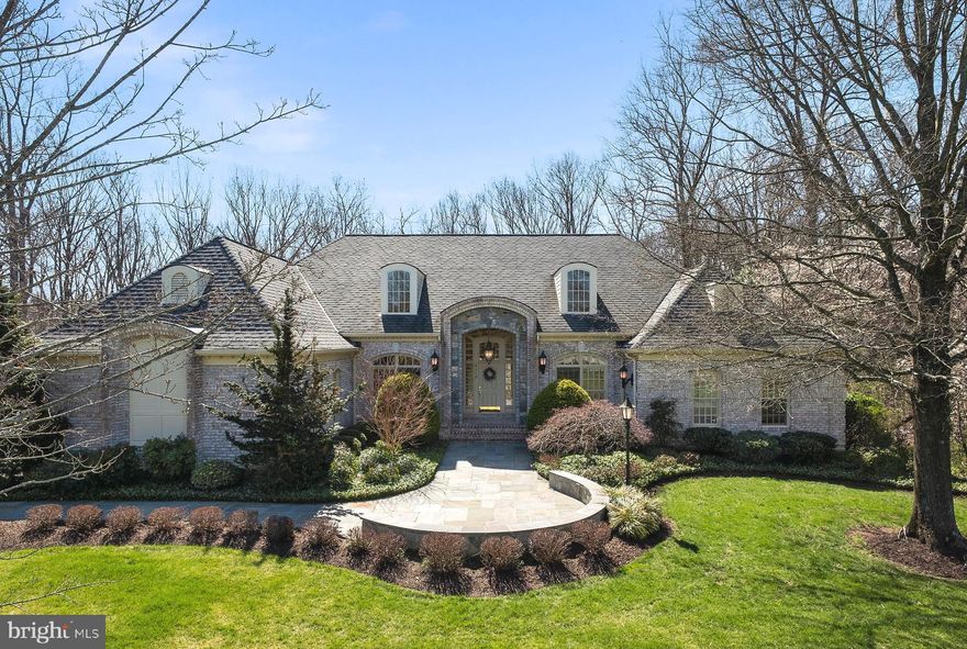 Best of the best - Monte West elegant custom built home with over 7800 square feet on 2.73 acres with breathtaking views of  treed parkland & a meandering stream.  Hard to find-main level living with outstanding custom features, nestled in the forest and in the heart of Oakton - easy access to I-66, downtown Oakton, Vienna and the Vienna Metro.  This 4 sided brick estate home has raised accent bricks in the front  - a visual architectural element with complimenting brick lintels over the exterior windows with keystone accent bricks.  Our home welcomes you with a natural flagstone walkway, a stone wall, a stunning 2 story front portico with a mixture of stone, flagstone and brick framing  the front door.  The  foyer has alabaster sconces and a matching chandelier with views though the living room to the outside parkland.  The library is off the foyer with natural cherry hardwood floors, walls, cabinetry with custom moldings and built in shelves.  The foyer steps down to the formal living room with the amazing views of the parkland.  Loads of windows offer a tremendous amount of natural light all day. This home has 6 wood burning fireplaces with gas logs. The living room has a wood inlay coffered ceilings w/recessed lights & a ceiling fan, a dramatic floor to ceiling gas fireplace with fluted accent moldings, a marble surround, a slate hearth and a custom wood mantle with wood moldings to the ceiling with alabaster sconces. Custom shelves are to the right of the fireplace.  The kitchen is perfect for the person who loves to cook and entertain. Offers 42 inch white raised panel cabinets with granite counter tops, a cook island with a 5 burner cook top and pendant lights, A Sub Zero refrigerator with matching cabinet doors,  a built in microwave, a double oven,  a walk in pantry, a breakfast bar and a double sink.  The breakfast bar opens to the family room and to the breakfast room with lots of casement windows - all looking over a treed forest.  The family room offers natural cherry floors, a flagstone floor to ceiling gas fireplace w/alabaster sconces, a ceiling fan and French doors to the 44 x16 foot veranda - a perfect place to entertain family and friends in the Spring, Summer and Fall.  The primary bedroom, family, and dining rooms access the veranda through French doors. The dining room offers coffered ceilings with hidden decorator accent lighting. On this level, the primary bedroom with a wet bar, floor to ceiling gas fireplace with a marble surround, coffered ceiling with recessed lights and a ceiling fan. The primary bathroom has white raised panel cabinetry, a  Jacuzzi jetted tub, double sink, marble floors, marble counter top and a large walk in closet with built in cabinetry and cubbies. A  door from the primary bedroom leads to the sitting room - a great place to sit, relax and unwind. There are 3 additional bedrooms on this level - all with ceiling fans, WI closets, and a full bath. The laundry room is on this level with built in cabinetry, a wet clothes dripping shower and a door to the side yard. The lower level is  accessed by two staircases. The lower level offers a recreation room with a floor to ceiling flagstone fireplace with a cozy sitting area, lots of windows, room for a pool table and an oak  bar with built in lighting, a sink, a dishwasher and a refrigerator.  Perfect for entertaining. T 5th bedroom with a gas fireplace w/walk in cedar closet, a full bath, an office with a gas fp,a built in desk & a curio cabinet that separates the exercise room.  There are 2 large storage rooms with cubbies and BI shelves for storage. 4 double French doors open to the terrace with the hot tub and a stone patio. A large backyard is perfect for summer games and family fun. As you can see when you walk through this home, it has stunning 180 degree views from nearly every room, workmanship is evident in the details. All in Windsong West!! A highly sought after upscale neighborhood with great schools and custom homes