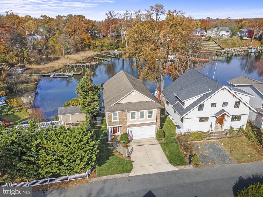 Escape to your own private slice of paradise and enjoy this incredibly well maintained waterfront home, nestled just off the picturesque Magothy River on Cool Spring Cove. With stunning creek and river views, an array of modern amenities, and unparalleled natural beauty, this home offers a lifestyle of tranquility and luxury. This waterfront home boasts 55 feet of prime waterfront, providing unobstructed views and direct access to one of Maryland's most enjoyed waterways. The open-concept living areas feature an abundance of large windows and sliding doors that fill the home with natural light and frame the ever-changing creek/river scenery. The living room's stone fireplace and hardwood floors add warmth and character to an area of the home you will surely spend lots of time in. The chef's kitchen is a culinary delight with all  stainless steel appliances, granite countertops, backsplash, custom cabinetry, and a center island. It seamlessly connects to the dining and living area, creating a perfect space for hosting family and friends. The master suite offers a private sanctuary with a spa-like bathroom, walk-in closet, and gorgeous views overlooking the quiet and picturesque creek. Boating, fishing, and water sports enthusiasts will delight in the property's deep-water pier, providing easy access to the river and the Chesapeake Bay. The  finished lower level includes a spacious family room with a wet bar, a guest bedroom, and walkout, ideal for indoor and outdoor entertainment.  Located in such an ideal area, you're just minutes away from shopping, waterfront dining (if you feel the need to leave the rear deck for a meal), parks, and top-rated schools. Annapolis, with its historic charm and waterfront attractions, is just a short drive away. Whether you're looking for a weekend getaway or a year-round residence, this waterfront property offers the perfect blend of serenity and convenience, providing an idyllic escape from the hustle and bustle of everyday life. Don't miss the opportunity to own this exceptional waterfront retreat. Experience the ultimate in waterfront living with breathtaking sunsets, natural beauty, and luxurious amenities. Schedule a showing today!