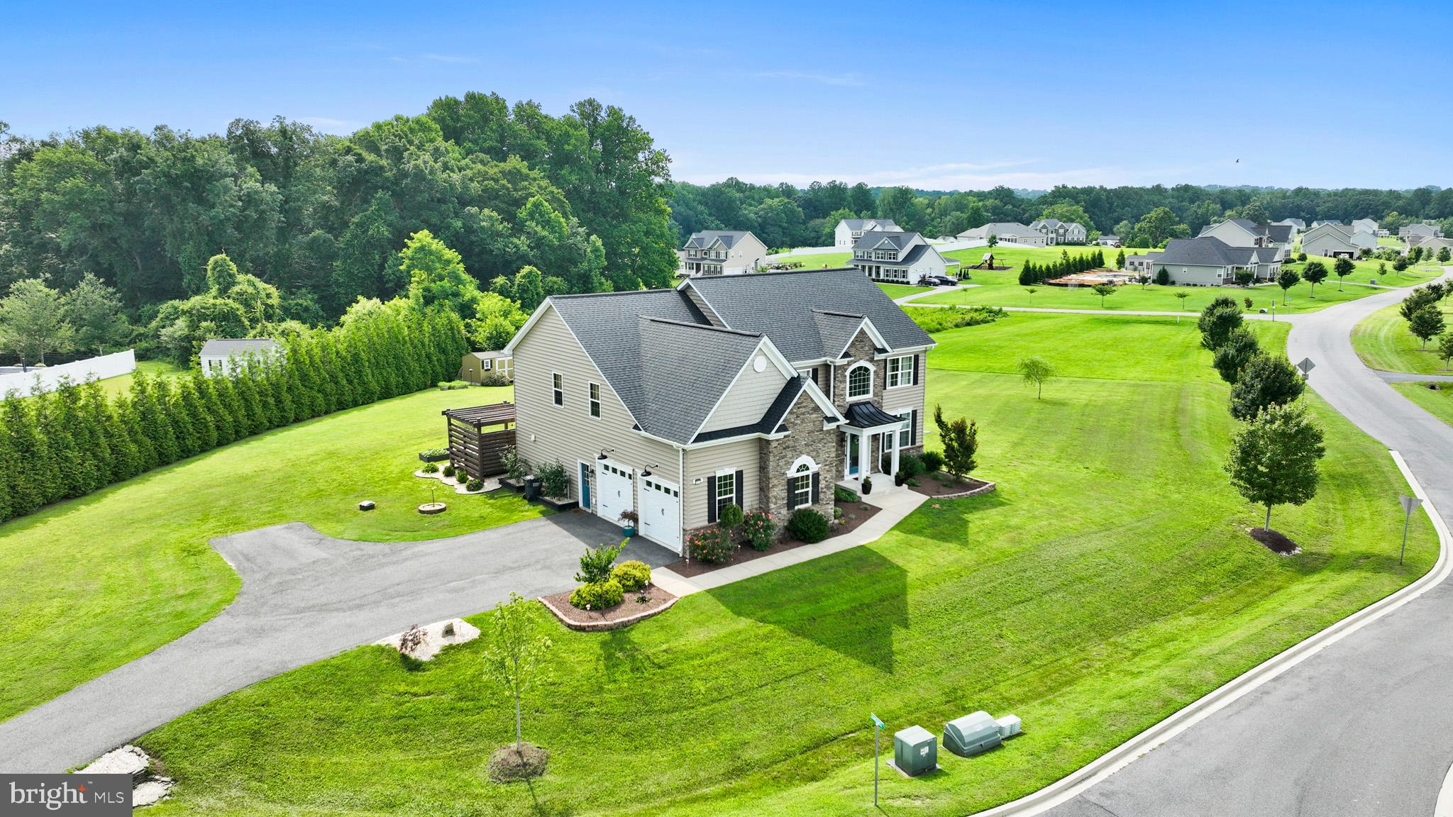 Don't miss your chance to own a home in one of Huntingtown’s most desirable and sought after communities—Twin Ponds. Skip the wait for new construction—this stunning Hampton model feels like new and is move-in ready. Showcasing over 5,200 square feet of beautifully finished living space across three levels, this home offers a seamless blend of comfort, elegance, and thoughtful design. Step into the soaring two-story foyer accented by a wrought iron staircase, setting the tone for the rest of this impressive home. The formal living and dining rooms are tastefully finished with custom trim and elegant paint, creating inviting spaces for entertaining or relaxing. The two-story family room is filled with natural light and centered around a striking stone fireplace. Just off the main living area is a spacious private study and a stylish half bath, perfect for working from home. The gourmet kitchen is a true showpiece, boasting upgraded cabinetry, slate appliances, a decorative range hood over a 36-inch cooktop, a farmhouse sink, designer backsplash, and a roll-out trash cabinet. The walk-in pantry is both functional and unique, featuring a custom door and beautiful brick flooring. Just beyond the kitchen is a bright sunroom, ideal for morning coffee or enjoying a peaceful read. Upstairs, you’ll find three generously sized secondary bedrooms and an expansive owner’s suite with cathedral ceilings, an oversized layout, and a massive walk-in closet. The luxurious primary bath includes dual vanities and a custom tile shower designed to impress. A spacious laundry room on the upper level adds convenience. The finished basement continues to impress with a large recreation room, a theater area complete with a built-in bar, a game room, and a full bath featuring a decorative shiplap wall. Throughout the home, you'll notice rich custom trim work, hardwood and luxury vinyl plank flooring on the main and upper levels, and thoughtfully selected designer lighting. You will also find a dual zoned heat pump system with gas backup, a propane tankless water heater and an oversized two-car garage with an exit door. Step outside to enjoy the custom pergola with a built-in bar top surrounding a relaxing hot tub. A large stamped concrete patio offers the perfect space for outdoor gatherings, while the professionally landscaped, level backyard provides room to entertain or install a future in-ground pool. Twin Ponds offers more than just beautiful homes—it’s a lifestyle. Enjoy access to a stocked fishing pond, scenic picnic spots, canoe and kayak access, walking trails, and a basketball court. All this, located just off Route 4 in the heart of Huntingtown and served by Calvert County’s award-winning school district.