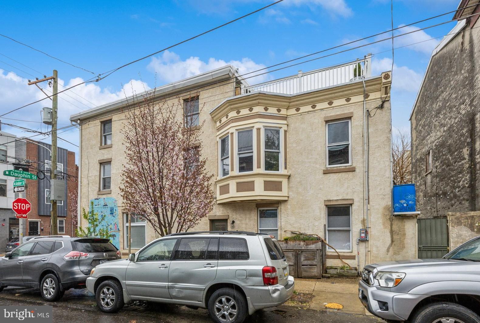 Here's something very rare: A large 3-story, 5+ Bedroom corner building with huge storefront type studio space (still legal for Commercial) on the 1st Floor, including a full bath. This is two blocks off Frankford Ave with great window light, and so many unique extras. 1ST FLOOR: Enter from the front on Dauphin or side entrance on Amber Street : 1ST FLOOR FRONT is a large studio space with exposed timbers, spot lighting, large picture windows and a stylish full custom tiled bath. 1ST FLOOR MIDDLE is large area for dining or extra living space, open into a contemporary full kitchen with stainless steel appliances, 5 burner gas cooking and plenty of cabinet space. 1ST FLOOR REAR exits to outside patio, very private, with room for plants, grilling and company. 2ND FLOOR: Large front bedroom with closet and incredible natural light on 2 sides (this is a corner property). Middle Bedroom - with window to Amber Street and Rear Bedroom with large bay-window, fan and incredible light. 2ND FLOOR REAR: Large full bath with clawfoot tub, custom tile and glass shower, and double vanities. Adjacent to bath is laundry alcove with large capacity washer/dryer. 3RD FLOOR: Front Bedroom with corner windows, and another bedroom/den area featuring walkout door to rooftop space for relaxing. BASEMENT is very large with plenty of space for storage, craft, music, and features Bilco type loading doors from the sidewalk for easy load-in/load-out. House has a long list of electrical, plumbing, and heating upgrades adding value to an already special find. This is steps away from Frankford Avenue where Fishtown & East Kensington have continued non-stop investment over the last two decades. The Market Frankford El Train is 3 blocks down on Dauphin St for a 10 minute trip to Center City. Interstate 95 is close for direct access to Bucks County, New Jersey, PHL Airport and Delaware. House is a pleasure to walkthrough and easy to show. --Thanks---