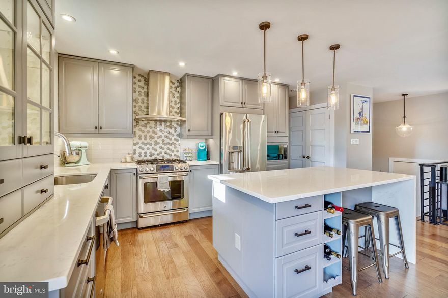 Gorgeous renovation with gourmet kitchen open to dining and living areas.  This is a cook's kitchen with  no detail overlooked!  Grey cabinetry with deep soft close drawers, custom glass tile backsplash, quartz countertops with waterfall feature on large eat-in island.  GE Cafe stainless steel appliances including a gas range w/stainless steel hood.   Living and Dining Room are open to kitchen for great flow and entertaining with wood floors throughout main level. Rear deck is accessed by French Doors off dining room and partially covered for outdoor seating/dining.  The master bedroom has generous closet space, and attached half bath.  Two additional bedrooms on main level, with one currently converted into a custom dressing room with built ins for endless wardrobe organization.  Main level bathroom has been fully updated with dual sink vanity and glass enclosed soaking tub/shower.  Basement features a large recreation room with recessed lighting, new wood tone composite flooring and a wood burning fireplace.  The basement family room offers a walk out to the patio and backyard.  There is a 4th bedroom located in the lower level as well.  Large utility room/laundry room with newer front loading washer and dryer. Detached garage accessed from Tayman Drive.  Huge amount of space for cars, recreational equipment or a workshop.  Hard wiring in place and new automatic garage doors