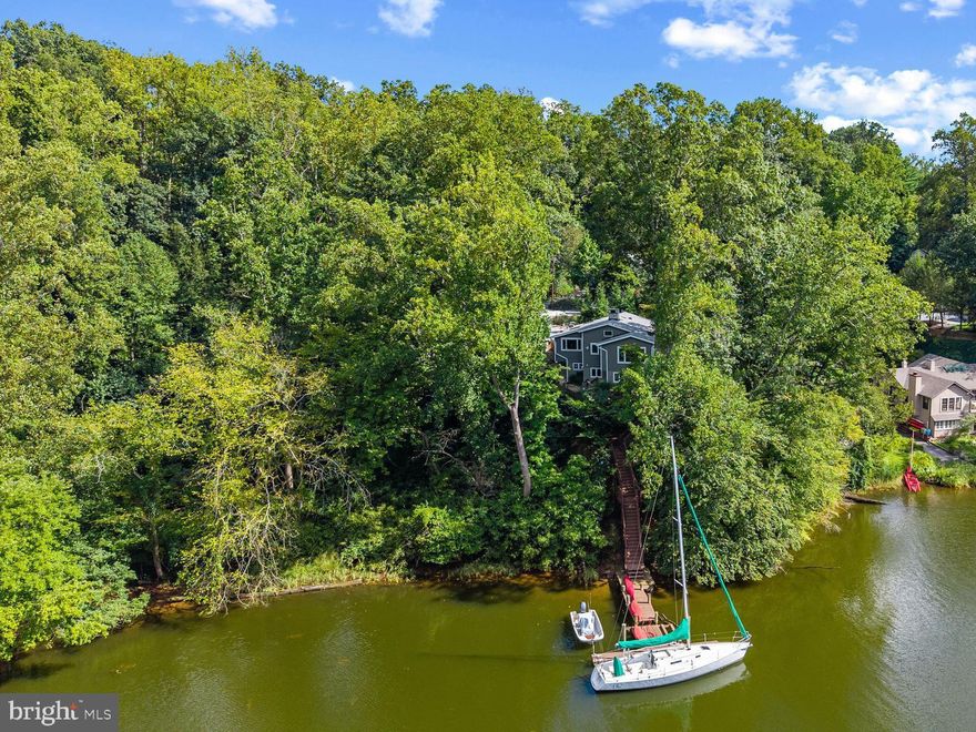 Perched on a waterfront bluff with picturesque views of Chase Creek, this charming cottage in Pines on the Severn provides the perfect turn-key escape. This home features the highly sought-after western facing water view which captures glorious sunsets. The multiple expansive decks are the perfect place to relax and enjoy a quiet evening with family and friends. The quaint front porch invites you into the light filled foyer where it becomes immediately evident that this is a truly special home. The attention to detail and the custom touches throughout bring a true sense of warmth and style. The main level features an open floor plan complete with a gourmet kitchen with island, living room with cozy fireplace, and waterside primary bedroom with ensuite bath and water views. Completing the level is an office/bedroom and additional full bath. Just off the living room/dining area sits an expansive deck which offers the ideal setting for al fresco dining and enjoying the water views of Chase Creek. Downstairs awaits the large family room, bedroom, full bath, kitchenette and laundry room. Head outside from this level to enjoy the sitting area with firepit, and large deck off the detached storage building. Descend the stairs to enjoy a day on the water from the pier extending into Chase Creek offering quick access to the Severn River, Annapolis Harbor and beyond. Your fellow mariners will be envious of the close proximity to the best boating/fishing/entertaining the Chesapeake Bay and its waterways, have to offer. The Pines on the Severn amenities are second to none including a boat ramp, marina, sandy beach, playground, canoe/kayak storage, basketball, tennis courts and nature trails. The Chase Creek swim club and scenic B&A bike trail are .5 miles up the street. Located in the Blue-Ribbon Broadneck School district and just 5 miles to downtown Annapolis and Severna Park. Convenient to Baltimore, BWI, Ft. Meade/NSA and Washington, DC. You literally have the best this region has to offer in a 30-mile radius. Welcome Home!