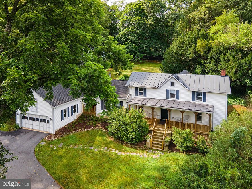 New price - exceptional value - priced below recent appraisal! Welcome to your new home in Round Hill—a charming blend of historic character and modern comfort. Originally built in the 1900s, this inviting farmhouse welcomes you with a traditional wide front porch perfect for gathering with friends or sipping your morning coffee. Step through the front door into the classic center hall foyer where a beautifully carved wood newel post sets the tone for the home’s timeless details. To the left, the formal dining room features original hardwood floors and chair railing - while to the right the formal living room offers fresh new carpet and great natural light. At the rear of the home, the kitchen opens to a generous breakfast room—ideal for casual meals or entertaining. The kitchen includes a peninsula with seating for three, unique greenhouse window over the double sink, plus access to a private stone patio for al fresco dining. The heart of the home is the two-story, light-filled family room with a wood-burning fireplace, creating a cozy space to gather year-round. From here, step out to a second stone patio or take the covered walkway to the detached two-car garage. A powder room off the foyer completes the main level. Upstairs, the spacious primary suite includes a private sitting area, walk-in closet, full bath, and its own balcony—an ideal retreat. Two additional bedrooms, both with original hardwood floors share a full hall bath. The fully fenced backyard features mature trees and garden beds—perfect for pets, play area or your next garden project. Fully renovated in the 1990's by well known local architect Beckham Dickerson. Recent upgrades include fresh interior paint, carpeting and LVP flooring in the kitchen and baths, new toilets, and new stainless steel dishwasher and refrigerator. Tucked just south of the village of Round Hill and only minutes to Route 7 this location offers small-town charm with unbeatable convenience. Don’t miss your chance to own a piece of history with all the comforts of today!