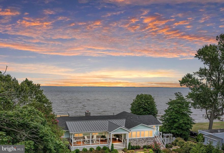 Don't miss this beautifully designed, meticulously updated, turn-key home on the Chesapeake Bay. Hidden from street view at the end of a cul-de-sac, this private waterfront retreat was fully renovated in  2022 and features HardiePlank siding, IPE decking, main-level primary suite, lower-level guest suite, chefs kitchen, walls of windows, home gym, 2 wood-burning fireplaces, and bonus 5th bedroom / 4th full bath in a separate studio apartment over the garage. Enjoy lushly landscaped grounds designed by Homestead Gardens,  extensive hardscaping, private pier with boat lift and electric / water hook-up,  and waterside deck.  Wake up to dramatic sunrises over the water;  enjoy afternoon sun and garden views from the front porch. The home and grounds are beautifully maintained and include a two-car detached garage with an EV charger and extra storage space. The Safe Harbor Marina is just down the street where members enjoy the pool, club house, beach, boat storage, and boat slips.  With over 3700 finished square feet plus the separate studio apartment, this home is ideal for entertaining friends and family. You just cannot beat the views!