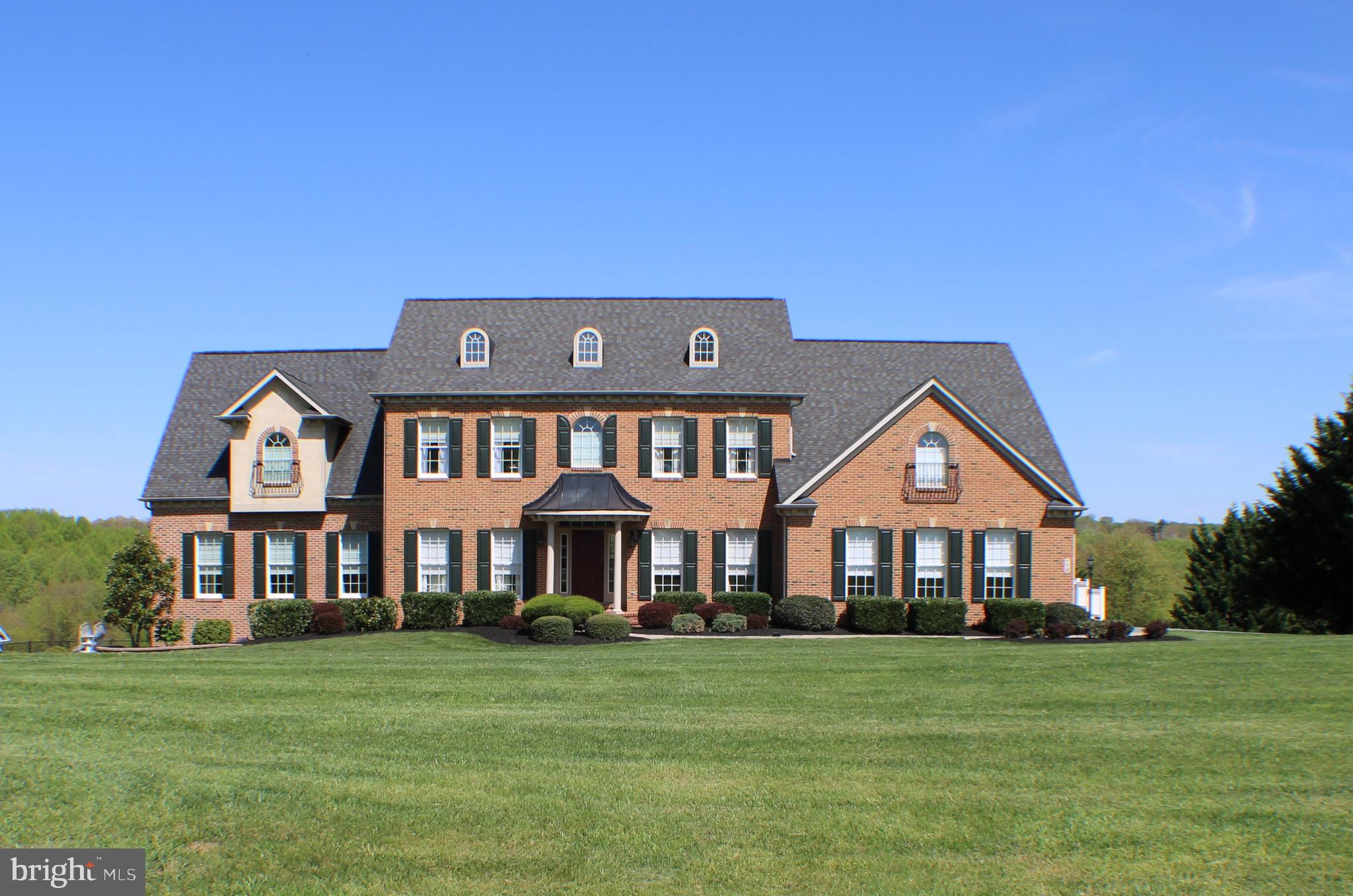 Welcome to this gorgeous estate home located at the end of a quiet cul-de-sac in highly sought after Western Howard County. This beautifully maintained French colonial is full of charming details such as 3-piece crown molding and hardwood floors throughout the main level which also includes a large bedroom with luxury en suite, laundry, walk-in closet and private balcony perfect for guests or multi-generational living. The gourmet kitchen with quartz counters, stainless steel appliances, professional style gas range, large island, walk-in pantry and coffee bar/beverage center is ideal for hosting family and friends. Right off of the kitchen, is the sunroom where large windows frame the stunning views of the surrounding countryside and deck overlooking a lagoon shaped in-ground heated pool. It is hard to believe that this pastoral entertainers’ paradise is only minutes from commuter routes to Baltimore, DC, Frederick, and Columbia. A formal dining room and living room, office with built-in bookcase, powder room, and family room with a wood burning stone fireplace and coffered ceilings round out the main floor. The upstairs boasts 3 expansive bedrooms with walk-in closets and attached en suite bathrooms, a laundry room and a huge owner’s suite with bathroom, walk-in closet, sitting room, gas fireplace and private balcony. The fully finished open concept basement with recreation room/home theater, barroom, 6th bedroom and bathroom are sure to impress. Besides the attached 2 car side load garage off of the main level, there is an additional 2 car garage with its own driveway at the basement level as well. Don’t miss out on this thoughtfully crafted home. An opportunity of a lifetime Is waiting for you!