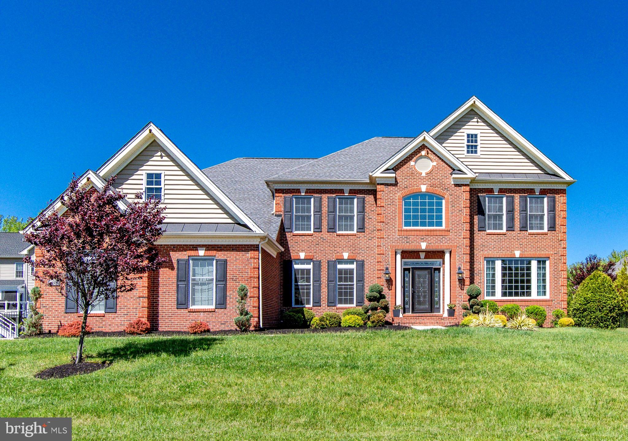 *** Photos recently updated! *** Stunning Toll Brothers estate in the gated Oak Creek Club offering over 7,300 sq. ft. of luxury living. The grand two-story foyer with marble floors and sweeping staircase sets the tone for this elegant home. Main level includes formal living and dining rooms, private office, 3-season deck, and a dramatic two-story family room with fireplace. Gourmet kitchen features granite counters, large prep island, stainless steel appliances, double oven, and walk-in pantry. The upper level boasts a primary suite with sitting room, dual walk-in closets, and spa bath, plus an additional en-suite and two bedrooms with shared bath. The finished walkout basement includes a wet bar, home theater, gym, rec room, bedroom, and direct access to a private backyard oasis with screened deck, covered porch, patio, and firepit. Additional highlights: 3-car garage with EV charger, irrigation system, and landscape lighting. Community amenities include golf, clubhouse, pools, tennis, fitness center, trails, and The Grove restaurant—only 30 minutes to D.C.