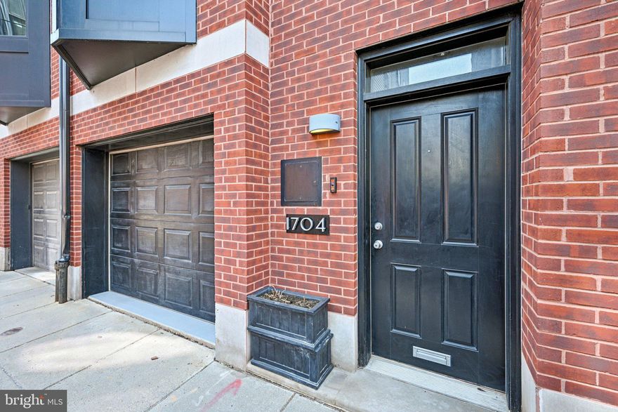 A beautiful, 2,500+ square-foot contemporary four-bedroom townhome with GARAGE parking, situated steps from Rittenhouse Square, overlooking a private pocket park. The ground level features a tiled entry foyer, a powder room, and a large bedroom. This floor also provides interior access to the attached garage, which includes a secondary full-sized refrigerator and additional storage. You'll also find solid wood floors and doors throughout most of the home. The second floor is a dedicated open-concept living space with oak hardwood flooring, recessed lighting, and a gas fireplace. The kitchen is equipped with cherry cabinetry, honed granite countertops, stainless steel appliances, a wine refrigerator, gas cooking, and a bay window with banquet seating. Sliding glass doors lead from the living area to a large deck. The entire floor just flows from one end to the other, which is perfect for entertaining. On the third floor, two bedrooms (one being used as a den) with custom closets share a gracious hallway bathroom. This level also contains a laundry area with a full-sized washer and dryer. The top floor is reserved for the primary suite, which features vaulted ceilings, a second gas fireplace, and custom closets. Sliding doors open to a private balcony with Center City skyline views. The primary bathroom includes a dual vanity and a newer, large glass-enclosed walk-in shower.