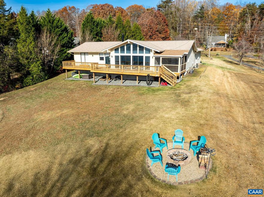 INCREDIBLE VALUE on this ultimate lakefront escape! Discover unparalleled tranquility and stunning wide-open water views from this spacious one-level home in the sought-after, gated community of Blue Ridge Shores on Lake Louisa. Key Property Features are 150 Feet of Water Frontage with a private Dock and Beach?ready for boating, swimming, and fishing adventures. Bright and Airy Open Floor Plan: The main living space features vaulted ceilings and a cozy fireplace, seamlessly connecting to the dining area and kitchen with a breakfast bar. Prime Outdoor Spaces: Enjoy laid-back lake mornings from the screened-in porch and sunset dinners on the lakeside deck. A dedicated fire pit area offers the perfect spot for wine or hot chocolate year-round. Flexible Living: Featuring 3 bedrooms, 2.5 baths, and a dedicated office, with over 2,300 finished square feet. Convenience & Storage: Includes an oversized attached 2-car garage and a paved driveway, all situated on a private, landscaped lot. Recent Updates & Community Perks Move-In Ready Condition: Peace of mind comes with recent updates, including a new roof and siding (2018), fresh paint and carpets (2025), a new water heater, replaced HVAC (2022), and new sliding doors in the living room.,Formica Counter,Painted Cabinets,White Cabinets,Fireplace in Living Room