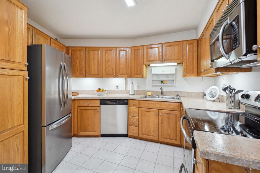 Enjoy access to all of the  amenities Leisure World has to offer when you move into this bright and sunny 5th floor condo with new fresh paint, laminate plank flooring and carpeted bedrooms. Separate Laundry closet and a spacious hall pantry are a real plus. The kitchen was previously undated and includes  all stainless appliances. Recent bedroom carpet and new commodes in both bathrooms. There is, also.  a  storage cage located on the building lower level.  The expansive glass enclosed balcony has a sunny panoramic golf course view.  Leisure World is a 55+ community that has both an HOA and Condo Association.  In addition there is an 18 hole golf course, indoor and outdoor pools and a well equipped fitness center is open to all residents in Club House II. There are many clubs and activities, including tennis courts, prickle ball, a fantastic wood working shop in Club House 1 and a grand ballroom which hosts a multitude of events through the year. T