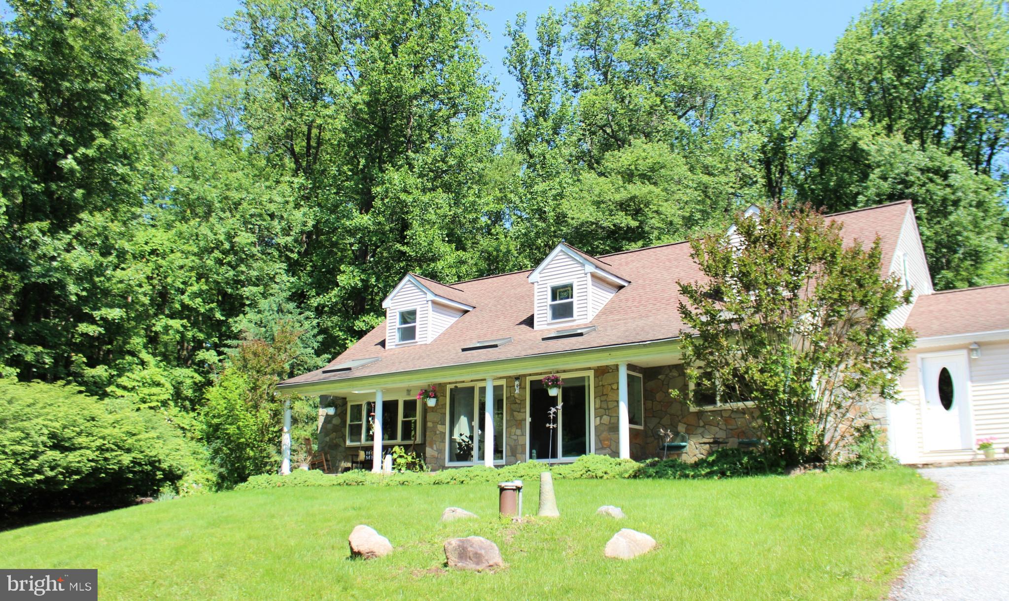 Discover serene living in this stunning 3-bedroom, 3-bath home nestled atop a gentle hill, surrounded by lush woodland views. A welcoming front porch offers the perfect vantage point to enjoy peaceful mornings and vibrant sunsets overlooking the natural landscape.
Bathed in sunlight from expansive windows and thoughtfully placed skylights, each room feels open and inviting, creating a seamless connection to the outdoors. The beautiful hardwood flooring throughout adds warmth and elegance, complementing the natural light. Enjoy the quiet charm of two sunrooms— ideal for morning coffee, birdwatching, or curling up with a good book. A dedicated library adds charm and functionality - offering a quiet escape for reading or working from home, while spacious living areas make entertaining effortless.
A whole-house generator ensures peace of mind during any power outages, and a shared private driveway adds an extra layer of privacy and seclusion. Whether you're looking for a full-time residence or a peaceful getaway, this home is a rare find where comfort and nature harmoniously meet.