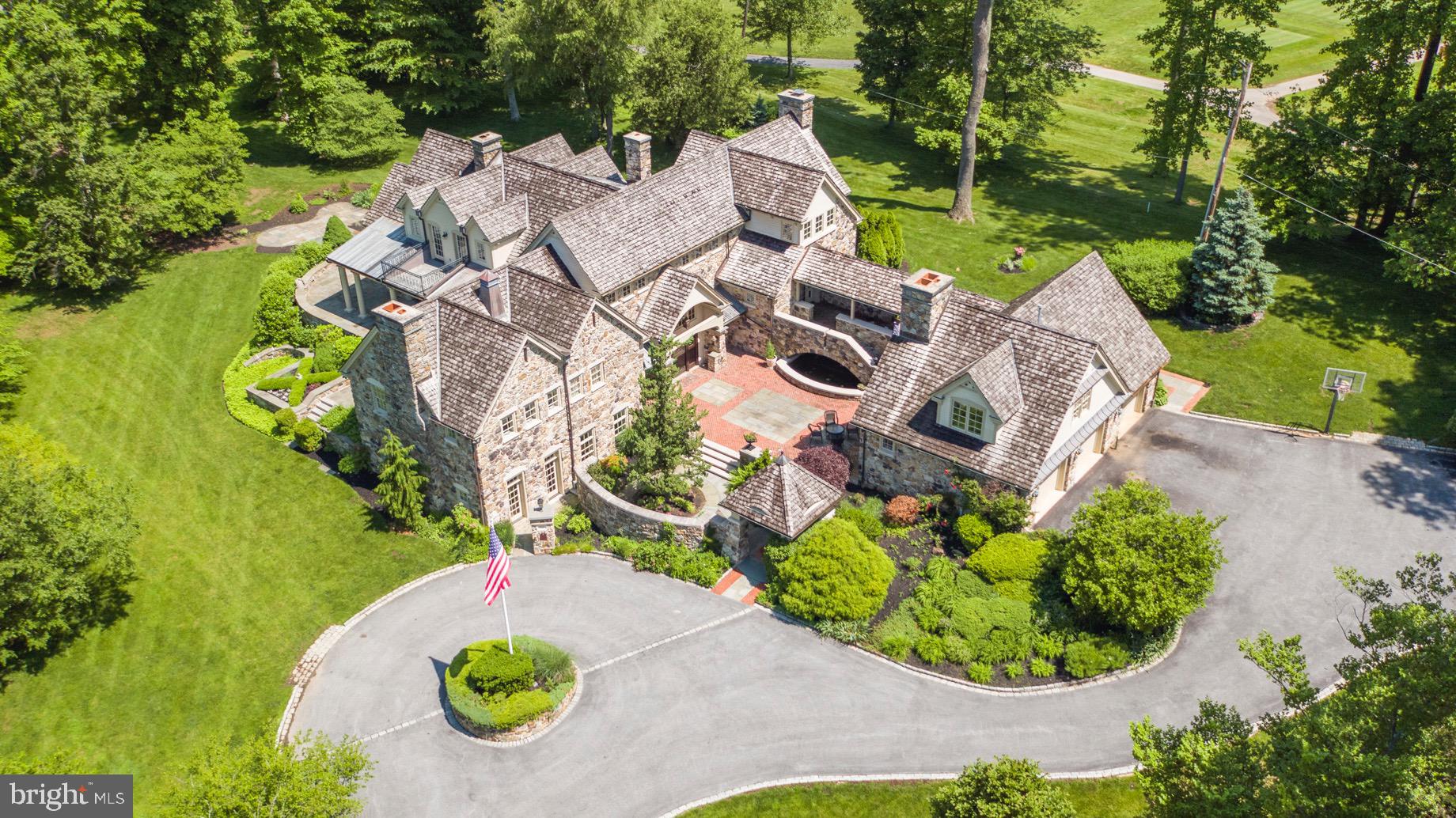 Transcending every expectation, this majestic architectural stone manor masterpiece sits on over 3 exquisite private acres. From its creation every part of the estate s residence and gorgeous grounds evoke a love of fine things, reverence to nature and love of family. One cannot help being in awe of this breathtaking home featuring 5 Bedrooms, 5 full Bathrooms and 2 Half Baths. Constructed of the finest materials and finishes this abode offers elaborate millwork, hardwood flooring, 12 Fireplaces, numerous French Doors leading to multiple Terraces, Patios, Covered Porch and Balconies that overlook a most glorious property. Approached through 2 stone pillars at the end of a cul-de-sac road, the winding drive leads to a circular motor court. Approach the Main Entrance from the sublime brick, stone and slate Courtyard featuring a Waterfall, Koi Pond and outdoor Stone Fireplace. Enter through the custom dutch Front Door and be enthralled by the Grande Foyer with vaulted ceiling, arched beams, limestone flooring, hardwood raised wainscot and the gorgeous stairway to the Main Floor Living area. The capacious Chef s Kitchen with custom cabinetry, granite countertops, L-shaped island, top of the line appliances leads to the Butler s Pantry/Work Station. All this is open to the Breakfast Area and Family Room with Fireplace with Limestone Mantel, large windows and French Doors opening to slate and stone Terraces. To the right of this area is the brick floored Mud Room, informal Powder Room, and outer entrance to the Breezeway which leads to the Guest Suite and oversized 3 car Garage. The Formal Dining Room is classically adorned with built-in China Cabinets, magnificent Brass Chandelier, shelved silver closet, hardwood floors and French Doors at 2 sides opening to the North Terrace and South Terrace. The Living Room/Great Room with hardwood flooring, Fireplace, French Doors to the Covered Porch opens to the Solarium with outdoor views and exposures on 3 sides. Open the French Doors, follow the walking trail and find yourself at the hand laid Stone Fireplace. The Master Bedroom Suite evokes beauty and serenity featuring vaulted ceiling with gorgeous lighting fixtures, Limestone Fireplace, sleeping area and sitting area. The elegant en-suite Master Bath has His and Her sinks, Custom Vanities, tumbled Marble Flooring, custom tile and millwork, Spa Tub, glass Steam Shower, private Water Closet and Fireplace. The Master hall leads to the custom Mahogany Dressing Room. The Second Floor has a Balcony that overlooks the Grande Foyer, and is comprised of 3 more Bedrooms, all with Sitting Areas, French Doors to Balconies and extraordinary en-suite Baths. The 2nd floor Laundry Room completes this level. The Lower Level, approached from either The Grand Foyer or the back stairs from the Family Room, brings you to the fantastic Recreation Room. Here one finds a Seating Area, Fireplace, a display wall of large proportion and built-in storage. This area also houses the pool table and game space. Continuing on, The Wine Room, awaits. A formal Powder Room, Trophy Hall with display cases, Exercise Room, are all on this level. The Club Room, approached from The Grande Foyer, is the perfect place to enjoy family time or host a large gathering. It is spectacular beyond words. The room has a high coffered ceiling, floor to ceiling beautiful Stone Fireplace, large windows and French Door leading to the motor courtyard. This masterpiece, surrounded by the most magnificent estate setting, offers a once in a lifetime opportunity to enjoy the very best. It is a dream come true!