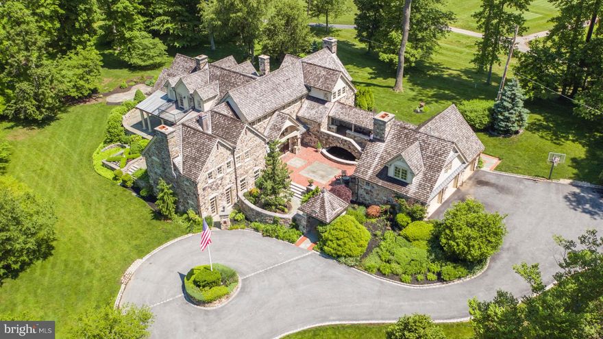 Transcending every expectation, this majestic architectural stone manor masterpiece sits on over 3 exquisite private acres. From its creation every part of the estate s residence and gorgeous grounds evoke a love of fine things, reverence to nature and love of family. One cannot help being in awe of this breathtaking home featuring 5 Bedrooms, 5 full Bathrooms and 2 Half Baths. Constructed of the finest materials and finishes this abode offers elaborate millwork, hardwood flooring, 12 Fireplaces, numerous French Doors leading to multiple Terraces, Patios, Covered Porch  and Balconies that overlook a most glorious property. Approached through 2 stone pillars at the end of a cul-de-sac road, the winding drive leads to a circular motor court. Approach the Main Entrance from the sublime brick, stone and slate Courtyard featuring a Waterfall, Koi Pond and outdoor Stone Fireplace. Enter through the custom dutch Front Door and be enthralled by the Grande Foyer with vaulted ceiling, arched beams, limestone flooring, hardwood raised wainscot and the gorgeous stairway to the Main Floor Living area. The capacious Chef s Kitchen with custom cabinetry,  granite countertops, L-shaped island, top of the line appliances leads to the Butler s Pantry/Work Station. All this is open to the Breakfast Area and Family Room with Fireplace with Limestone Mantel, large windows and French Doors opening to slate and stone Terraces. To the right of this area is the  brick floored Mud Room, informal Powder Room,  and outer entrance to the Breezeway which leads to the Guest Suite and oversized 3 car Garage. The Formal Dining Room is classically adorned with built-in China Cabinets, magnificent Brass Chandelier, shelved silver closet, hardwood floors and French Doors at 2 sides opening to the North Terrace and South Terrace. The Living Room/Great Room with hardwood flooring, Fireplace, French Doors to the Covered Porch opens to the Solarium with outdoor views and exposures on 3 sides. Open the French Doors, follow the walking trail and find yourself at the hand laid Stone Fireplace. The Master Bedroom Suite evokes beauty and serenity featuring vaulted ceiling with gorgeous lighting fixtures, Limestone Fireplace, sleeping area and sitting area. The elegant en-suite Master Bath has His and Her sinks, Custom Vanities, tumbled Marble Flooring,  custom tile and millwork, Spa Tub, glass Steam Shower, private Water Closet and Fireplace. The Master hall leads to the custom Mahogany Dressing Room.  The Second Floor has a Balcony that overlooks the Grande Foyer, and is comprised of 3 more Bedrooms, all with Sitting Areas, French Doors to Balconies and extraordinary en-suite Baths. The 2nd floor Laundry Room completes this level. The Lower Level, approached from either The Grand Foyer or the back stairs from the Family  Room, brings you to the  fantastic Recreation Room. Here one finds a Seating Area, Fireplace, a display wall of large proportion and built-in storage. This area also houses the pool table and game space. Continuing on, The Wine Room, awaits. A formal Powder Room, Trophy Hall with display cases, Exercise Room, are all on this level. The Club Room, approached from The Grande Foyer, is  the perfect place to enjoy family time or host a large gathering.  It is spectacular beyond words. The room has a high coffered ceiling, floor to ceiling beautiful Stone Fireplace, large windows and French Door leading to the motor courtyard. This masterpiece, surrounded by the most magnificent estate setting, offers a once in a lifetime opportunity to enjoy the very best. It is a dream come true!