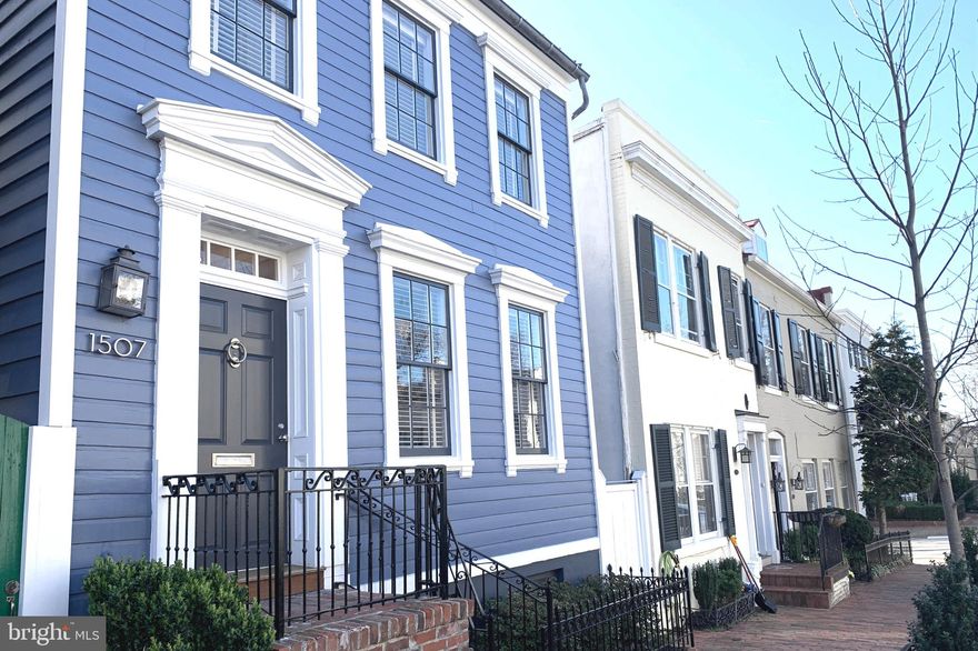 Every inch of this glorious residence has been gifted with extraordinary attention. Acclaimed architect, Christian Zapatka, created this exquisite gem, and the owners have enhanced their home even more with today’s technology and details that continue to perfect the beauty and comfort of enjoying life in Georgetown. From excavating the interior and rear exterior delivering an open and bright space for entertaining and family life to providing the latest in electronic wonders like a roof top cell tower, it is hard to imagine what else one would need. The balancing between protecting the integrity of its 200-year heritage while providing for modern conveniences, this residence surpasses the test. The main level speaks elegance with its unique architectural details journeying from living room to the dining room. These two areas are enriched with marble-surround fireplaces and unbelievable sunlight. The library/office and ensuite powder room echo the stunning blue from the home’s exterior as do the mirrored bookshelves on one of the four built-in bookcases.  The classic original Federal staircase leads to two ensuite bedrooms, both designed as their own private sanctuaries. Light floods into these suites, and closets and storage abound. The bathrooms have been designed to be timeless and stylish with all fixtures and tiles from Waterworks.  A wrought iron balcony provides a view of the back gardens. Descending the side staircase, the island countertop catches the eye and says this kitchen is unforgettable. A gourmet chef would be jealous of the spacious cooking area, and the kitchen overflows with incredible storage.  The dining area easily serves for both family gatherings and more formal affairs. The open lower level continues to the family room with its clever multi-purpose paneling and two walls of floor-to-ceiling windows and doors that provide entrance to and views of a sumptuous and spacious perennial garden which connects to the parking area. The third bedroom can easily be an office with its built-in desk and cabinets. The adjacent bathroom with greyish-blue and white Waterworks tiles is easily accessible to guests as well. Just as impressive as the property itself, its location on one of Georgetown’s prettiest and friendliest blocks, along with its proximity to restaurants, shopping, and parks, creates an enviable setting for this royal sapphire jewel.