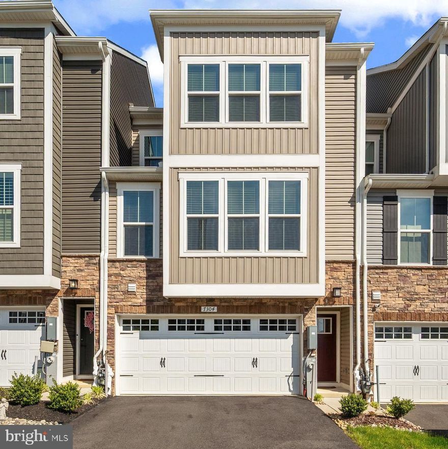Welcome to 7304 Isabella Road — a stunning 2022-built townhome that perfectly blends modern design with everyday comfort. From the moment you arrive, the handsome stone-and-board-and-batten exterior, and two-car garage make a lasting first impression. This home offers LVP throughout all levels, an efficient tankless hot water heater, custom blinds and shades, tons of storage, high ceilings and more.
Step inside to a sun-drenched, open-concept main level where a spectacular gourmet kitchen takes center stage. Gleaming white cabinetry, stainless steel appliances, and a large quartz island with seating for four invite both casual mornings and weekend entertaining. 
Upstairs, retreat to a spacious primary suite featuring a tray ceiling, walk-in closet, and a spa-inspired en suite bath with dual vanities and a tiled glass shower. Two additional bedrooms, a spacious hall bath and a conveniently located upper-level laundry room round out the upper floor.
The entry level has a half bath, family room that can also be a large office and access to the backyard.
One of the home's most impressive features is the private covered balcony, complete with a striking floor-to-ceiling stone fireplace — perfect for unwinding. With a community pool just steps away, a fitness center, club house and a sought-after location offering easy access to Rt 32, 95, 29, 70 shopping, dining, and commuter routes, this home offers the lifestyle you've been waiting for. Don't miss it!