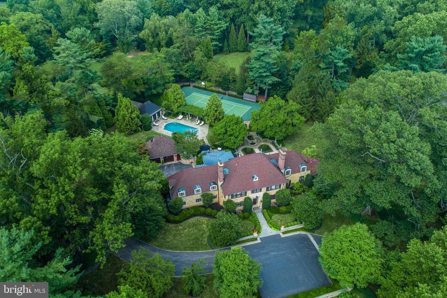 Virtual tours are available! No in-person tours until the shelter in place order is lifted. Please contact the Listing Agent for more details.  Youtube Aerial Video Tour: https://youtu.be/Qevq5fvDP2w. Exceptional living awaits the discerning buyer seeking the ultimate sophisticated Main Line estate property, on one of the most exclusive streets in Lower Merion Twp. Located in premier Northside Bryn Mawr, this magnificent classic stone home sits on over 2 acres of breathtaking gated grounds. Mature trees, gorgeous gardens & tranquil garden pools provide the utmost beauty and privacy. Exclusive recreation is yours with the amenities of a fabulous pool & spa, well-appointed guest house & regulation-size tennis court for perfecting your game. This truly rare gem, built in 1938, epitomizes elegance in every way. The prestigious residence with Ludowici tiled roofs and multiple outdoor terraces & living spaces has been meticulously restored and fully renovated, down to the last stunning detail.Unparalleled luxury continues to unfold inside, with a gracious front to rear entrance hall that opens to the terrace & gardens. Exquisite fireplaces, millwork, wainscot paneling, hand-painted walls & restored oak floors with inlay enhance the tremendous character. Entertaining is at its grandest in formal living & dining rooms. Hosting continues in a substantial sunroom with exposed stone floor & walls, which includes a custom built-in bar & media cabinetry, and offers panoramic views of the gardens. Read & relax in the cherry-paneled library with fireplace. The custom chef s kitchen features top-of-the-line finishes & appliances and a butler s pantry. Adjacent is a breakfast area & spacious family room with radiant heated flooring, windows on all sides & French doors that open onto the terrace, outdoor kitchen & gardens. Formal & informal powder rooms + a convenient mudroom complete the expansive main level. The staircase brightened by a large window at the 2nd level landing ascends to tranquil sleeping quarters. A luxurious retreat, the master suite has a vaulted ceiling, sitting area, generous fitted walk-in closets & spa-like marble bath. Three additional spacious bedrooms, one en-suite, and a renovated marble full bath accommodate family & guests. Perched on level 3 is a private 5th BR suite with a walk-in cedar & other closets. The renovated walk-out lower level is a haven all its own boasting a wood-paneled media room with stone wood-burning fireplace, fully-equipped gym, wine room, wrapping room, laundry, powder & storage rooms. Ridgewood Road s finest home also includes a full-property generator, attached 2-car temperature-controlled garage, detached 2-car heated garage & location beyond compare.  This proper Main Line estate offers the very best of town & country living.