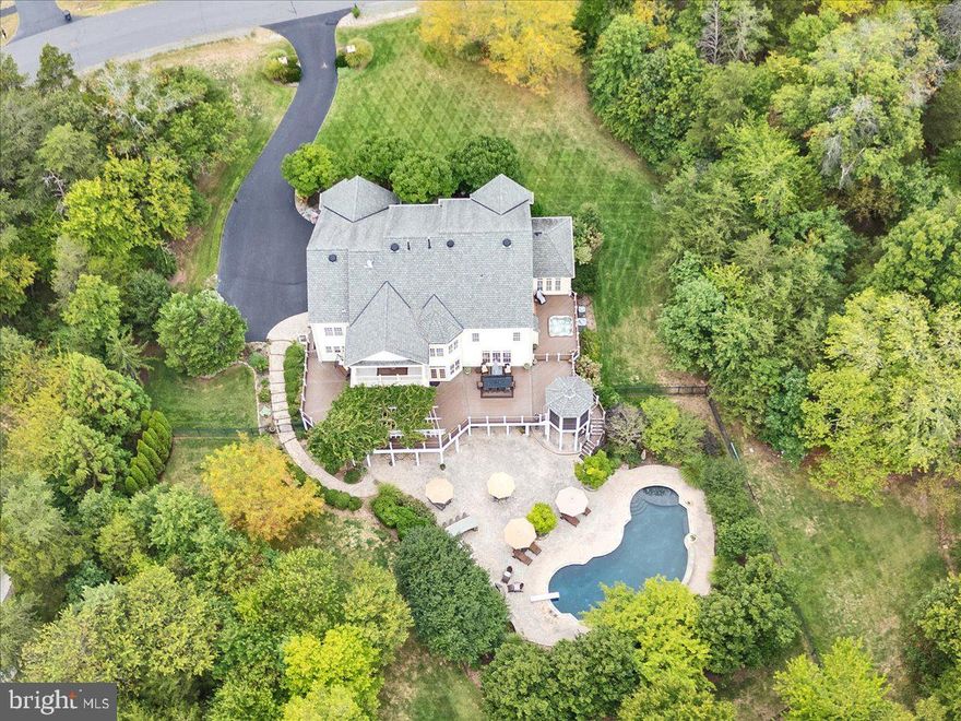 Open House Sunday 6/22 1-3pm.  Welcome to an impeccably maintained estate home on 3 acres. This home features 6 bedrooms, 6.5 baths and nearly 8000sf of well-appointed living. Enjoy an exquisite outdoor oasis consisting of a 40,000 gallon saltwater pool with diving board, fountains and tanning ledge; Jacuzzi hot tub; outdoor kitchen with grill, refrigerator, and bar seating; stone fireplace, extensive hardscape area, enormous wrap around deck with screened gazebo, and mature professional landscaping all nestled on a private wooded lot. Inside, architectural details abound. Hardwood floors, moulding details and 10 ft ceilings carry through main level (9' on upper and lower levels). The 2-story foyer welcomes with a curved staircase with iron balusters and is flanked by beautifully appointed formal living and dining rooms. A side conservancy offers a private retreat with three walls of windows overlooking the lush landscaping. The stately home office features built-in wood cabinetry and  French doors. The heart of this home is the  bright and open gourmet kitchen. High-end stainless steel appliances include Subzero refrigerator, Miele dishwasher, and Dacor 6-burner range, wall oven, built-in microwave and warmer drawer.  An oversized island anchors the space that includes two breakfast bars, a walk-in pantry, separate butlers serving pantry area, prep sink, high end cabinetry, a generous-size breakfast area, a rear 2nd staircase and miles of counter space. The kitchen connects to the spacious family room that boasts a gas fireplace, coffered ceiling and remote control shades. The rear sunroom is a delightful space to enjoy morning coffee and connects to the outside spaces of this home. This level also includes a half bath, an oversized laundry area with cabinetry and a side door, mudroom, an additional full bath and access to the 3-car garage that features an organization system on all walls, cabinetry, a work bench and pull-down stairs to the attic that has been outfitted for storage in addition to access. Upstairs, the primary suite is quite the retreat! The spacious bedroom and sitting area features hardwood floors, tray ceiling and access to a private covered veranda. Back inside, the spa bathroom has an oversized walk-through shower with dual shower heads, a soaking tub, two vanities with ample cabinetry, dual water closets and the entrance to the divided walk-in closet. Four additional bedrooms and three additional bathrooms (including a "Jack and Jill") as well as two linen closets complete this level. The lower level of this home is ready for entertaining and features true walk-out access to the rear of the home and full-size windows. An open recreation room provides unlimited options for gathering, gaming and play!  A well equipped wet bar boasts a microwave, beverage refrigerator, dishwasher and sink.  A cozy gas fireplace offers a conversation corner after a game of pool (pool table and equipment convey). Adjacent is a home theater with tiered seated space, mounted screen, projector and audio equipment (media room equipment conveys). A mirrored gym, 6th bedroom, full bath and ample storage area complete this level. Special features include neutral decor throughout, heated front walkway (never shovel again!), newer roof (2012) 4 HVAC zones (2 replaced 2018, 2020), additional insulation added for energy efficiency, wrought iron fencing with 4 gates, stone water table around exterior of home, 23 zone irrigation system and exterior lighting, pride of ownership abounds! Cedar Crest features over 200 homes on 3-4 acres with public water and sewer and walking trail throughout the community. Close to Rt 50, Rt 29, Loudoun County Parkway, Dulles Airport, Stone Springs Hospital . The sellers have established an offer deadline for Sunday June 22  at 7 PM