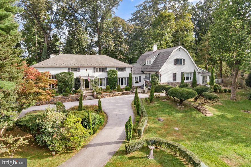 Welcome to “Rockwood”, a one-of-a-kind estate in the heart of Devon’s most prestigious neighborhood.  Originally built around 1900, this home was once the former Booth School and Carriage home now combined as one of the main line’s unique estate homes.  Featuring 6 beds and 5 full baths with over 6600 sq. ft of interior living space, an attached 3 car garage, and in-ground pool.  The 1.4 acre property is located on one of the highest points in Devon which provides sweeping views and seclusion surrounded by the beauty of English landscaped gardens, manicured grounds and iconic barrier privet hedge that transcends all the properties on this exclusive block in Easttown.
Walk up to the front door and admire natural gas lite lanterns giving the glow of yesterday’s stately luxury.  Inside there is a welcoming center foyer hallway with staircase and large coat closet, beyond is a first floor office/study.  The living room is grand with 11’ soaring ceilings, crown moldings, 9’ tall double-pained windows, fireplace with fruitwood mantle and timeless tiger maple wood floors overlooking the lush front and rear landscape.   The dining room features custom built-ins with room to throw lavish dinner parties for 15-20 guests providing an unforgettable dining experience.  The gourmet kitchen is bright and sunny with granite countertops, double in wall ovens, Wolf gas cooktop and island workstation.  The kitchen is open to a breakfast room with fireplace and hallway spilling into the rear yard and back patio.   Beyond is the second family room with built-in bookshelves, a wet bar and cabinetry for refreshments & cocktails after a long day.  The family room is completed with another fireplace and mantle with gleaming hardwood flooring and beveled glass featuring all day natural light.   From this area find the main bedroom suite features a bright sunroom, large sitting area which overlooks a private garden with private outside door. This primary bedroom suite also features a solarium facing the front on the house with bluestone patio area and stone wall overlooking the pool.  The primary suite includes double walk-in closets, an oversized bathroom with double vanity, separate tub & shower.  This wing of the home also features another large private bedroom with full hall bath.   Back at the main foyer go up the staircase to find three more bedrooms with two full baths (one en-suite bathroom) a playroom, cedar closet and enormous storage attic.    The Private Guest House/Apt.  offers an outside separate entry and features a Living Room, Full Kitchen/Dining area, 2 bedrooms and a full bathroom with hardwood floors and architectural features throughout, includes a rear second floor deck with large Dutch-door off kitchen, perfect for In-Laws, an Au Pair or “legal” apartment rental at $2,200 per month income.
Updates include, a newer lifetime Slate-Line dimensional asphalt roof with copper accents, new ornamental half round gutters, LED landscape lighting, Haddonstone architectural features, Walpole lighting, updated high efficiency natural gas hot water heaters, septic system installed in 2007, updated boiler in 2016 and regularly serviced HVAC systems. This superior location is within a short walk to the Devon train station, Devon yards, Devon Horse Show grounds, Whole Foods, shopping, restaurants, the Radnor Walking Trail and part of the coveted TE Schools.