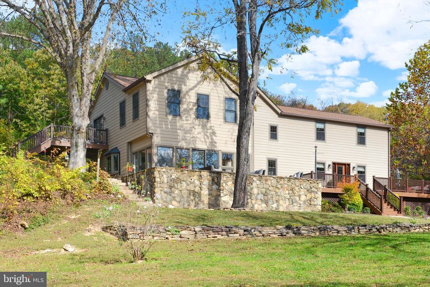 Welcome to Piece of Quiet Farm, a remarkable 30-acre estate that promises peace and
your very own nature sanctuary. The property features impressive barns and multiple
outbuildings. From the moment you start down the tree-lined driveway, you experience
the tranquility of this natural retreat.
The beautifully restored 1890 log farmhouse ,with additions added on in 1985 & 2012, blends historical charm with modern
updates, offering four bedrooms, three full baths, two half baths and top of the line
Hardy Plank cement siding. You’ll notice hardwood flooring throughout, tongue-and-
groove knotty pine ceilings, solid doors, and custom walnut trim crafted from trees
grown on the land itself. In the cozy family room, history comes alive with its stone
hearth, gas fireplace, and a powder room boasting a vanity designed like fine furniture.
Nearby, the keeping room includes a woodstove set against another stone hearth,
original exposed log walls, and rugged beams - perfect as an office or reading nook on
the first floor.
A spacious, contemporary kitchen added in 2010 showcases custom maple cabinetry,
granite countertops, stainless steel appliances, double wall ovens, an electric cooktop, a
huge island, and ample space for dining.
Upstairs, you’ll find four bedrooms, including one dating back to the 1890s, as well as a
generous primary suite with vaulted ceilings, arched windows, walk-in closets, ceiling
fans, and a luxurious owner’s bathroom with a soaking tub and separate shower.
Another bedroom offers a private ensuite bath, while one more provides access to a
private wooden deck with breathtaking views of the countryside.
The lower level is partially finished, providing a recreation room and a half-bath.
Car enthusiasts will appreciate the heated and cooled four-car garage, plus there’s an
open barn suitable for storing farm equipment. An additional outbuilding contains a fully
finished second-floor office area with climate control.
Outdoor living is at its best here, with a vast front porch, a stone patio, gardens, and fruit
orchards ready for your gardening ambitions. Nature lovers will enjoy the spring-fed
pond stocked with trophy bass and sunfish, complemented by a private duck blind and a
pavilion equipped with electricity for gatherings. Wildlife abounds, with regular visits
from deer, turkeys, and foxes.
Nestled at the base of Sugarloaf Mountain, this property is close to the C&O Canal and
Potomac River and such activities as hiking, biking, boating and fishing. It is a short
drive to shopping, schools, restaurants and commuter routes. The property has excellent internet service through Starlink  (current owner frequently works from home and uses streaming services).  The Urbana commercial district and Historic Downtown Frederick are both a short drive away. Come tour this
breathtaking property today!