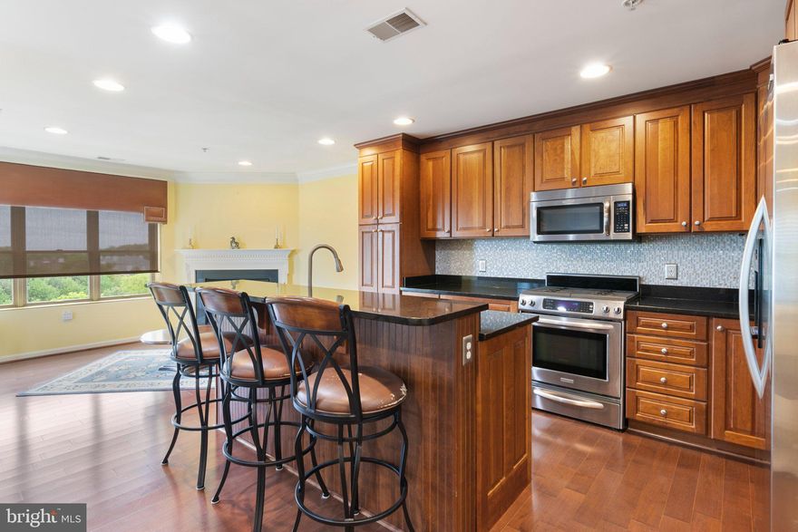 Experience breathtaking views from this beautiful east-facing condo unit, where morning sunlight fills the space with natural brightness. Upon entering, you'll immediately notice the luxurious wood flooring throughout the main living areas.  The open layout features a spacious living area and a large kitchen with an island that overlooks the living room, making it perfect for entertaining friends. Adjacent to the kitchen, a keeping area with a gas fireplace provides the ideal spot for a cozy seating arrangement by the fire or an informal eating space for your morning coffee.  Next to the kitchen is a formal dining room, highlighted by a chandelier and built-in bookcases, perfect for displaying your china or storing a cherished book collection.  Step outside to the balcony located just off the keeping room, and enjoy sweeping views overlooking Lutherville and toward Loch Raven.  The hallway leads to three bedrooms, a laundry room, and a hall bathroom. The main bedroom features an en suite bathroom with a walk-in shower, while the third bedroom offers flexibility for use as a study. The laundry room includes storage shelves and houses utilities such as the HVAC system and water heater.  The kitchen boasts beautiful wood cabinets complemented by stainless appliances, black granite countertops, and a stunning mother-of-pearl tiled backsplash.  This unit includes a dedicated parking space in the basement garage, with additional ample parking available on either side of the building. There is also a separate storage unit down the hall.  The building is currently undergoing a renovation of the lobby and hallways, featuring new paint, carpet, and furniture.
More photos will be available as we approach the on-market date!