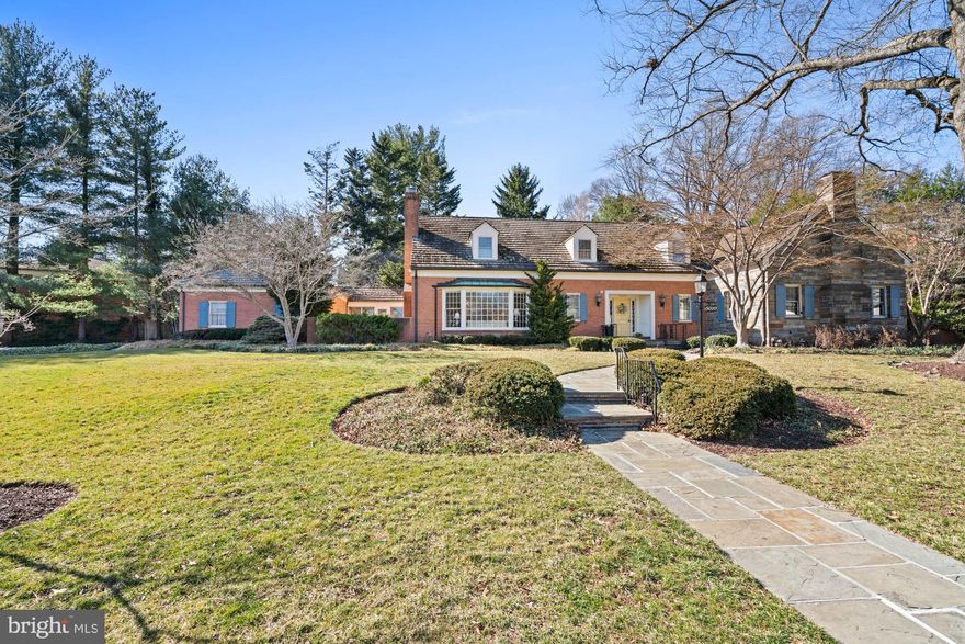 A sprawling estate home ready for your decor updates, this stately, custom-built Cape Cod is one of those rare finds – a classic home designed to stand the test of time while providing the perfect ‘blank slate’ exciting to today’s homebuyers. Some homes are simply where you live. Others are where you celebrate life, create memories, and leave a lasting legacy. Set on over half an acre of beautifully landscaped grounds, this estate was carefully curated as a sanctuary, not just for its owners, but for the birds and wildlife that grace its gardens. Mature trees, sculpted boxwoods, and flagstone patios that follow the natural curves of the land create a setting that is both private and poetic.
At the heart of this home is an expansive main-floor owner’s wing – a true rarity in Bethesda on this scale. More than just a bedroom, this private suite is an oasis, complete with a large en suite bath, dual vanities, soaking tub, walk-in closet, and an adjacent study/library. Whether seeking a quiet place to reflect, work, or unwind, this wing offers the flexibility and comfort that high-end buyers desire – without sacrificing connection to the rest of the home.
With 6,700+ square feet sprawling across three levels, this home’s design is both elegant and effortlessly livable. Expansive gathering spaces allow for hosting on any scale, from formal dining to fireside conversation in the grand living room with a bay window and ornate fireplace. The center-island kitchen, adjoining family room with fireplace, and sunroom span the back of the home. The slate-floor sunroom features walls of windows and skylights that flood the space with natural light and invite the beauty of the outdoors. From there, the  access to the breezeway and garage make coming and going a breeze.
The upper level offers five generous bedrooms and two baths, a huge unfinished attic space, and additional storage.  The large lower level provides an additional bedroom, full bath, and recreation spaces – ideal for multigenerational living, hosting guests, or creating a private retreat for a caregiver or au pair.
This is a home that embraces its surroundings. The previous owner, an avid birder, designed the gardens and green spaces as a haven for both feathered and human visitors alike. From morning coffee on the flagstone patio to evenings spent watching the sun set behind the trees, every element of this estate was crafted to offer peace, beauty, and a connection to nature – all just moments from the heart of Bethesda.
For those seeking a truly special home – one that offers timeless design, unparalleled comfort, and a setting unlike any other – this is an opportunity not to be missed.