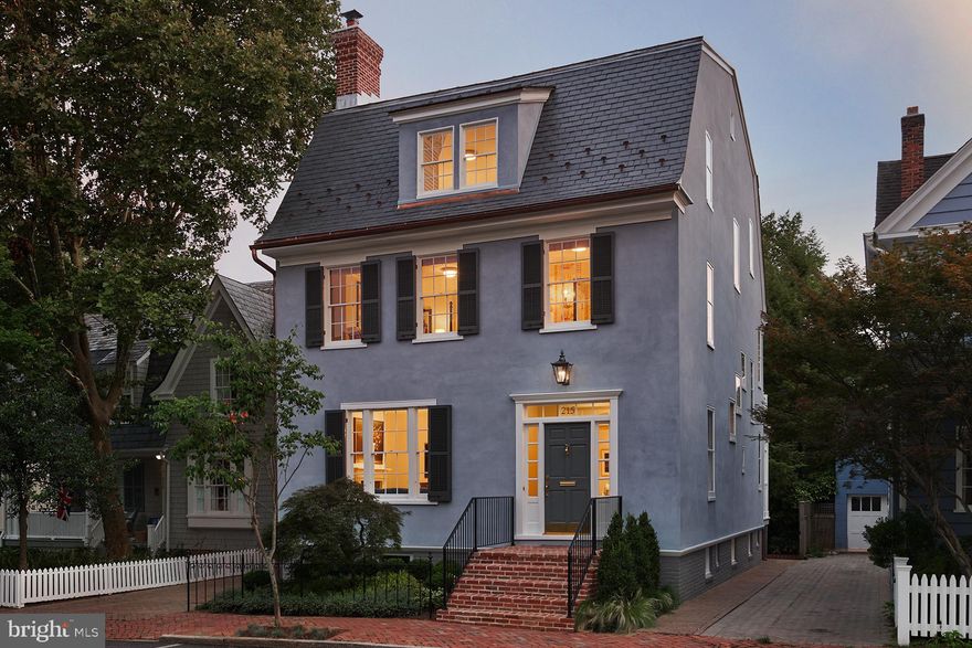 Exquisite, complete remodel of prominent Historic property in the heart of downtown Annapolis. 
Located on prestigious King George Street, and featured in the Annapolis Home Magazine, this home has been seamlessly restored and preserved to its original architecture and charm all while adding an updated, modern, and elegant look with high-end finishes throughout.  
The home has been thoughtfully designed and constructed LEED Gold certified by Winchester Construction with over 4,900 sq ft of living space, 5 bedrooms, 5.5 bathrooms, finished lower-level suite with 2nd kitchen, oversized rooftop balcony, stately curved brick patio, and private driveway with parking.  
The complete restoration includes a refurbished exterior, featuring a new Buckingham slate roof, copper flashing and gutters, repaired and upgraded windows, trim, and a charming front entrance. 
Upon entrance into the home, you are greeted by a stunning foyer, new white oak floors, high ceilings, bright natural light, two gas fireplaces, and a three-floor, cantilevered stairway with a mahogany handrail and a medallion of the Naval Academy insignia embedded in the cap on the first-floor banister.  
An addition was added that includes the kitchen, eat in breakfast room and a set of French doors that lead to the outdoor patio. The large gourmet kitchen features marble countertops, top of the line stainless-steel appliances, custom navy-blue cabinetry with classic brass hardware and Sirca lightening. The open concept, recessed lighting, custom crown and shoe moldings, and quality of materials used throughout the home exude class.  The second and third upper levels offer 4 bedrooms including the primary suite with custom closets, upper-level living room, gas fireplace and walk-out to the rooftop balcony.  
All bathrooms have been completely remodeled with heated floors, marble countertops, custom marble & tile showers, Sirca lightening and Classic brass hardware. 
The finished lower level provides an additional full kitchen, additional bedroom, full bathroom, laundry room, and mechanical room. 
This home provides direct access to the United States Naval Academy, is located steps from the water, boutiques, shopping, and restaurants. Convenient access to Rt. 50 and 97 which provides direct access to Baltimore, BWI, Ft. Meade/NSA and Washington, DC.  Welcome home!
